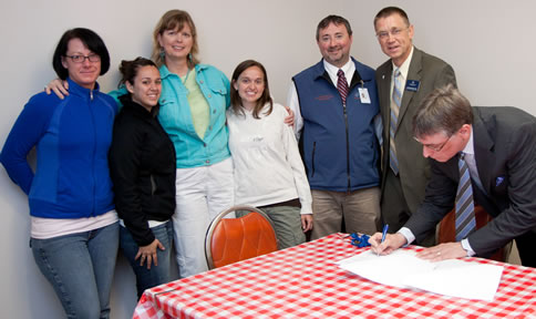 Left to right:ï¿½Clark College students Nova Sehorn and Adrienne Sousa, Health and Physical Education Professor Lisa Borho, student Tiffany Bunn, and Dean of Health Sciences Blake Boweres welcome Concordia University Profess or of Exercise & Sport Science Dr. Joel Schuldheisz and (signing the agreement) Concordia Provost Dr. Mark Wahlers.
