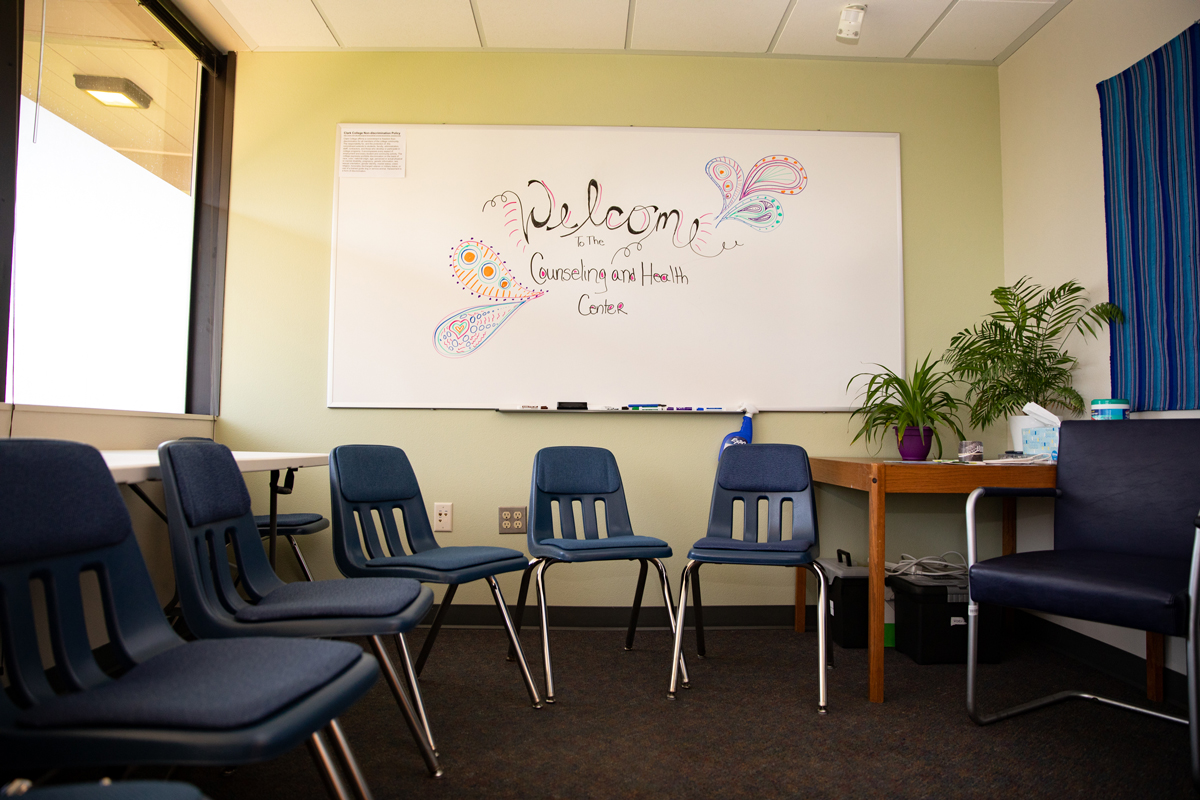 Image of a room with empty chairs in a circle with a white board that says "welcome"