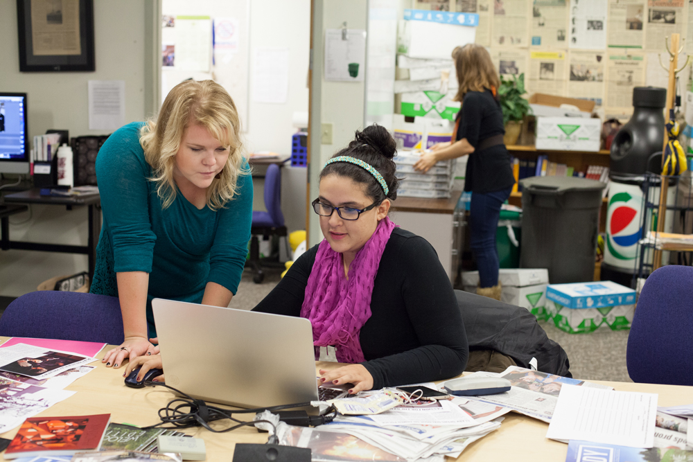 Two students work on laptop