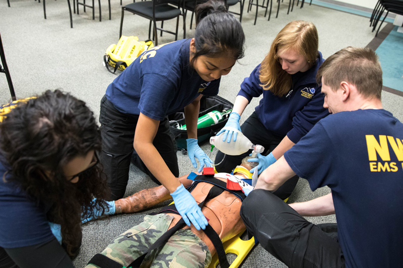 students in lab, practicing on a plastic human replica