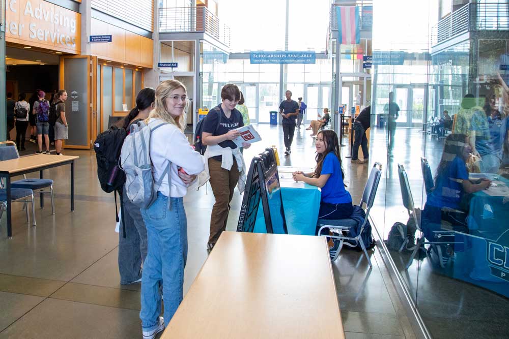 Students standing in line to be helped by a college employee.