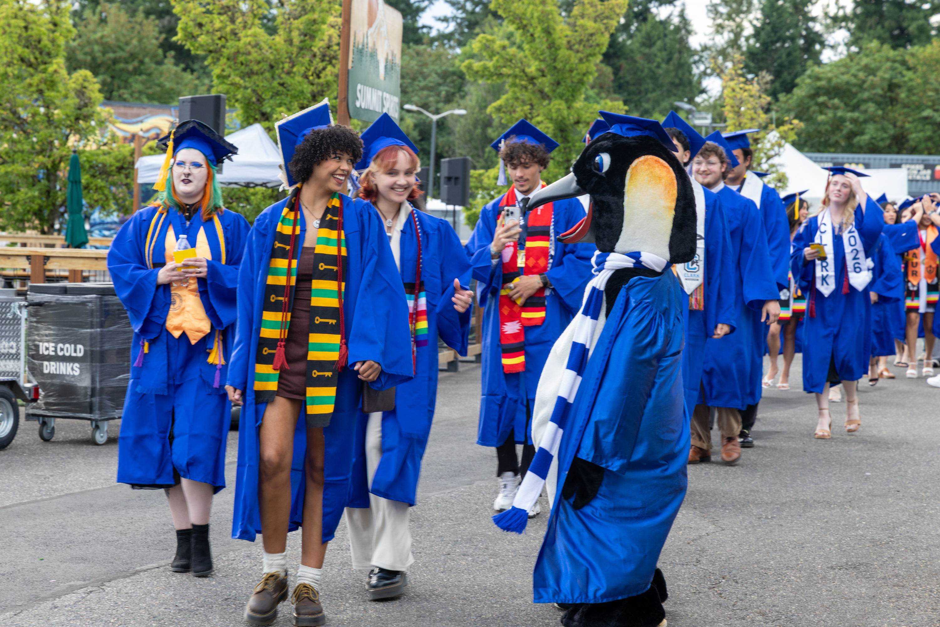 Graduates greet a penguin mascot