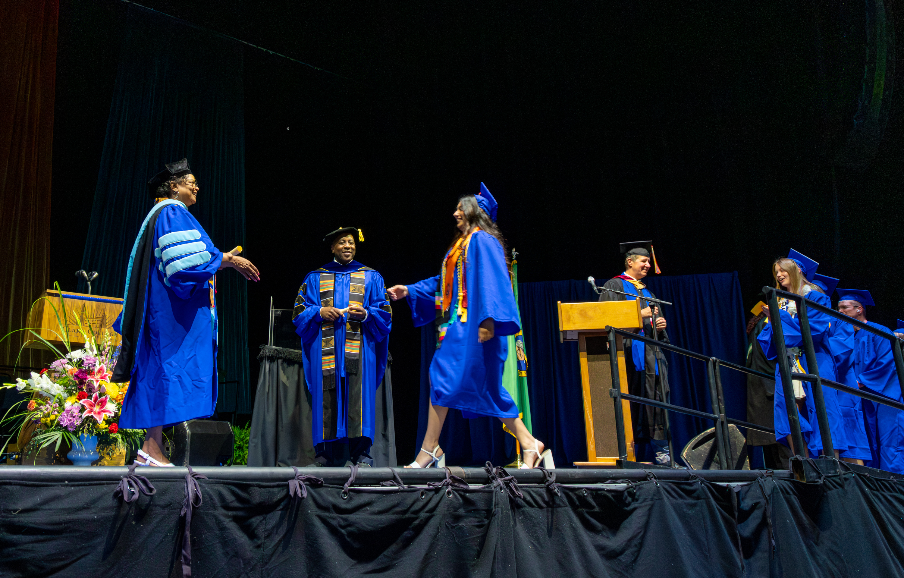 Dr. Karin Edwards greets a graduate walking across the stage