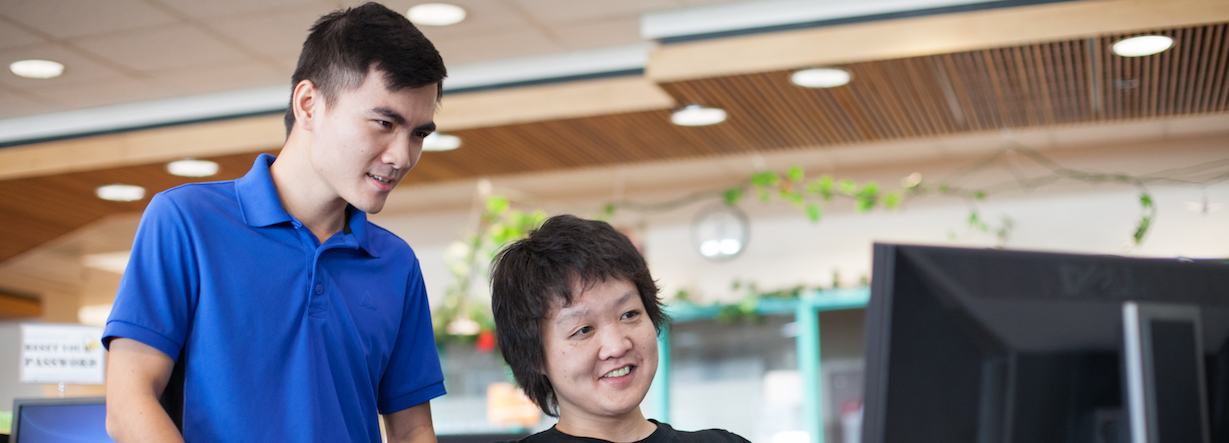 Students help each other at a computer