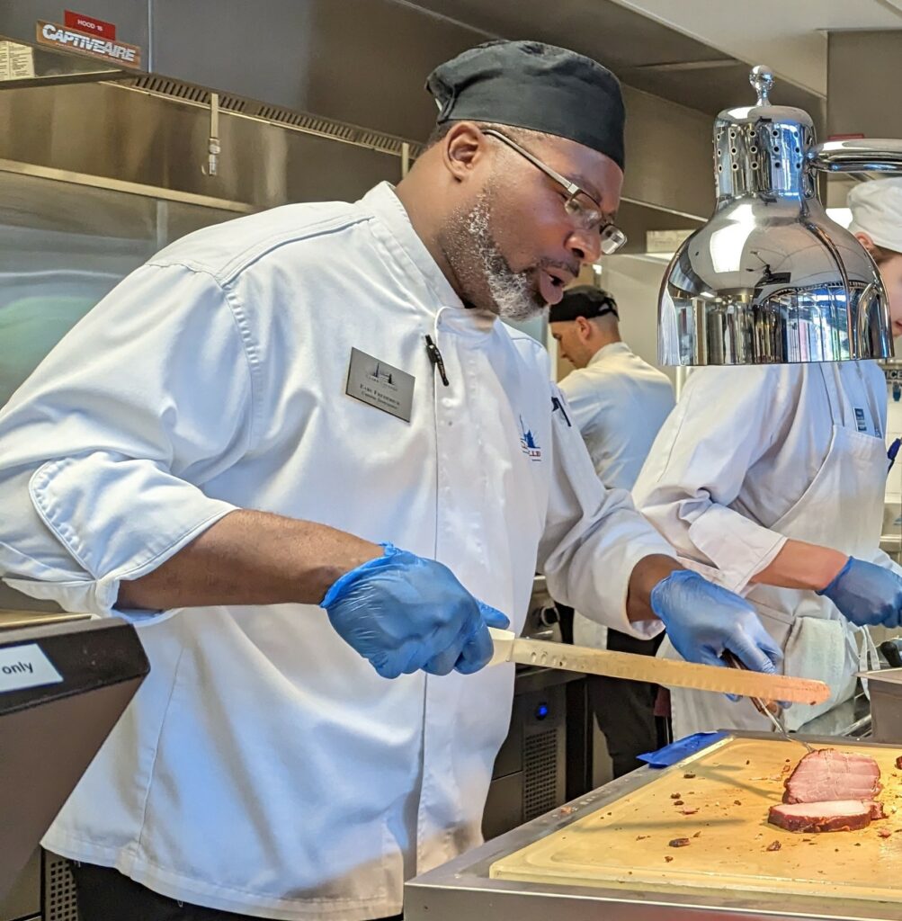 Exceptional Faculty Award recipient Chef Earl Frederick serves up BBQ during Juneteenth 2023.