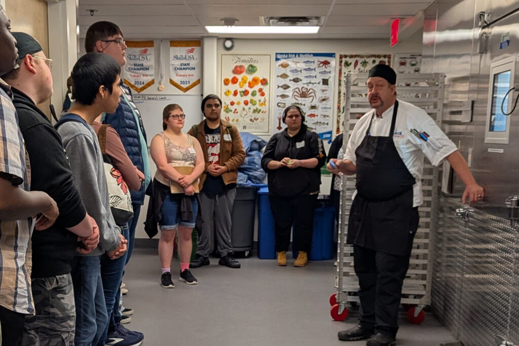 people standing outside a walk-in cooler