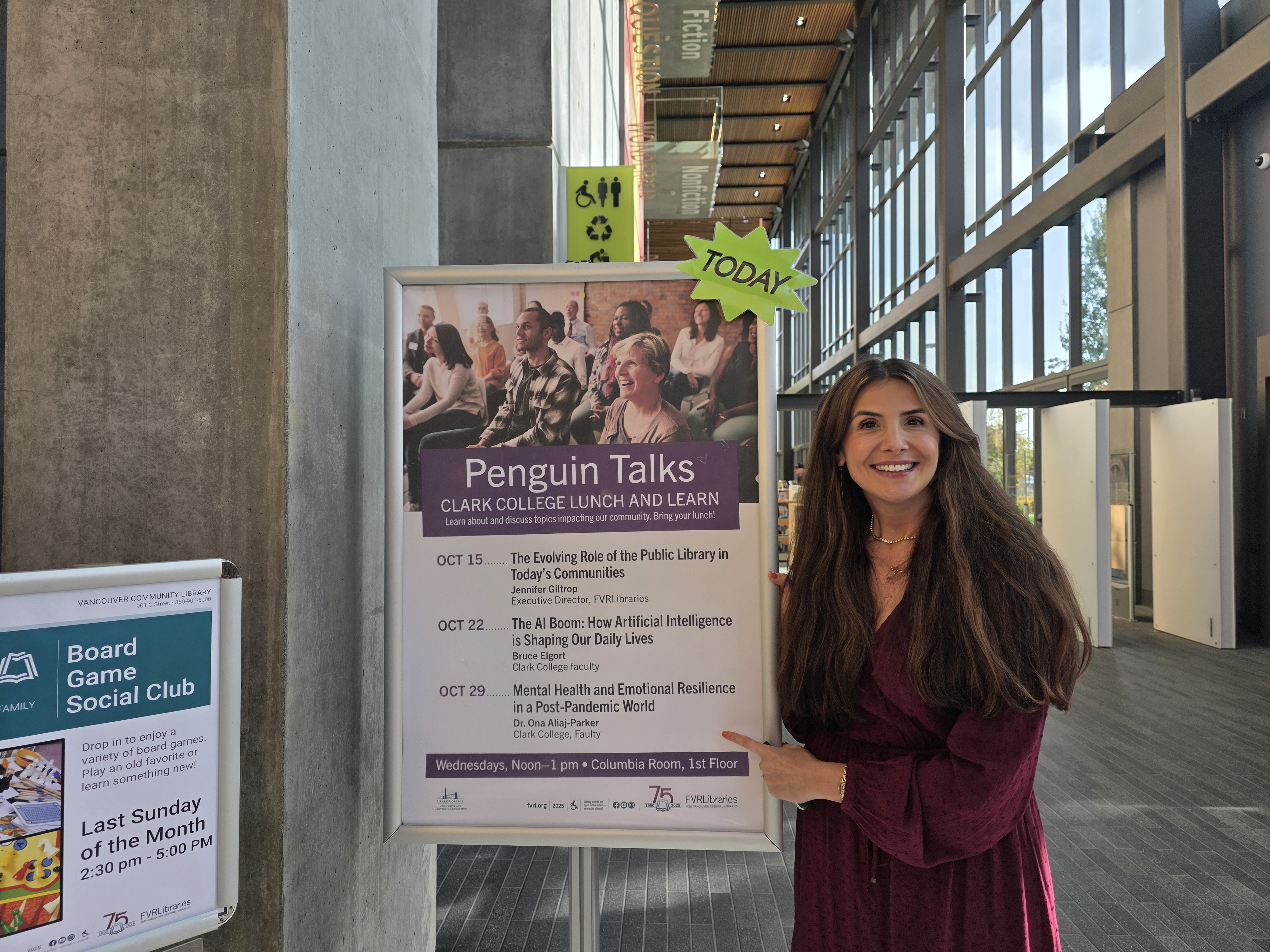 Dr. Ona Aliaj-Parker pointing to a sign about Penguin Talks