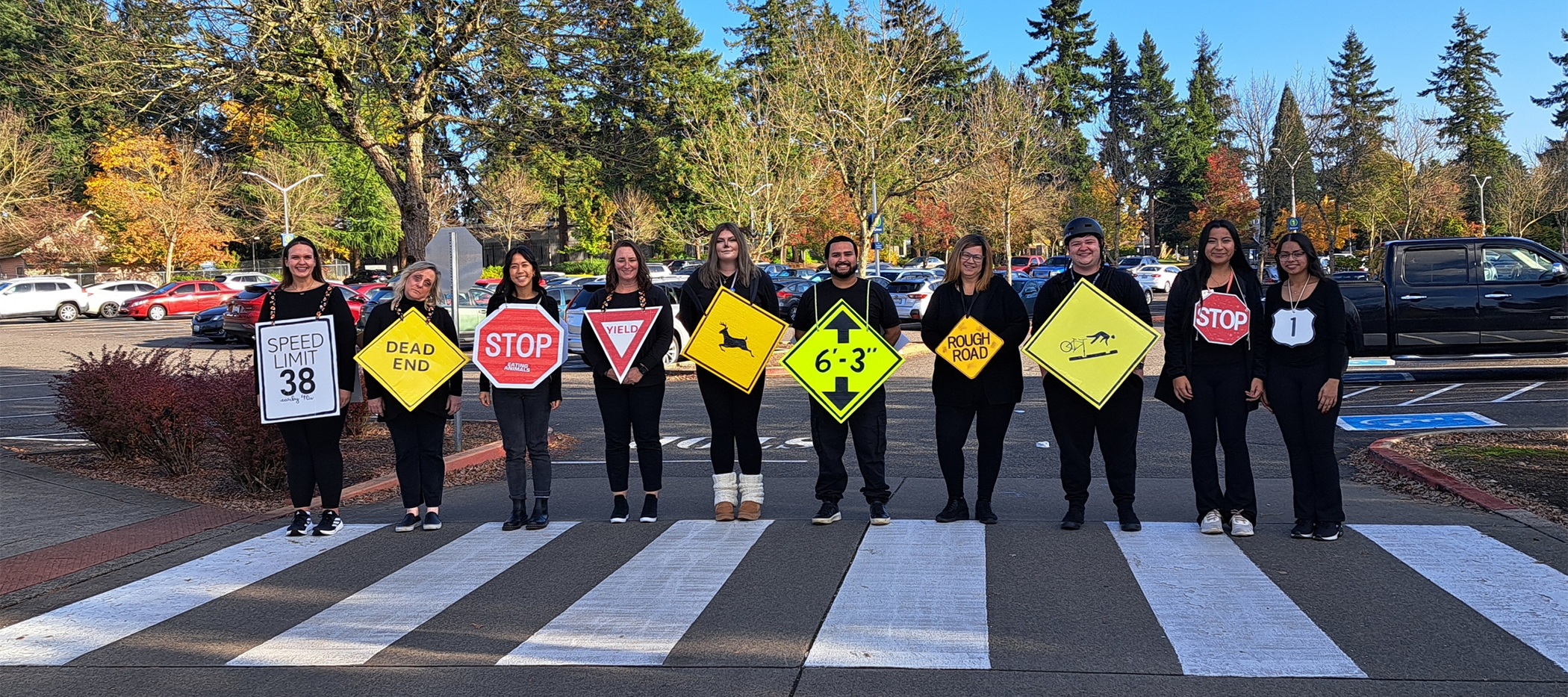 Entry Services team lined up on crosswork wearing street sign costumes
