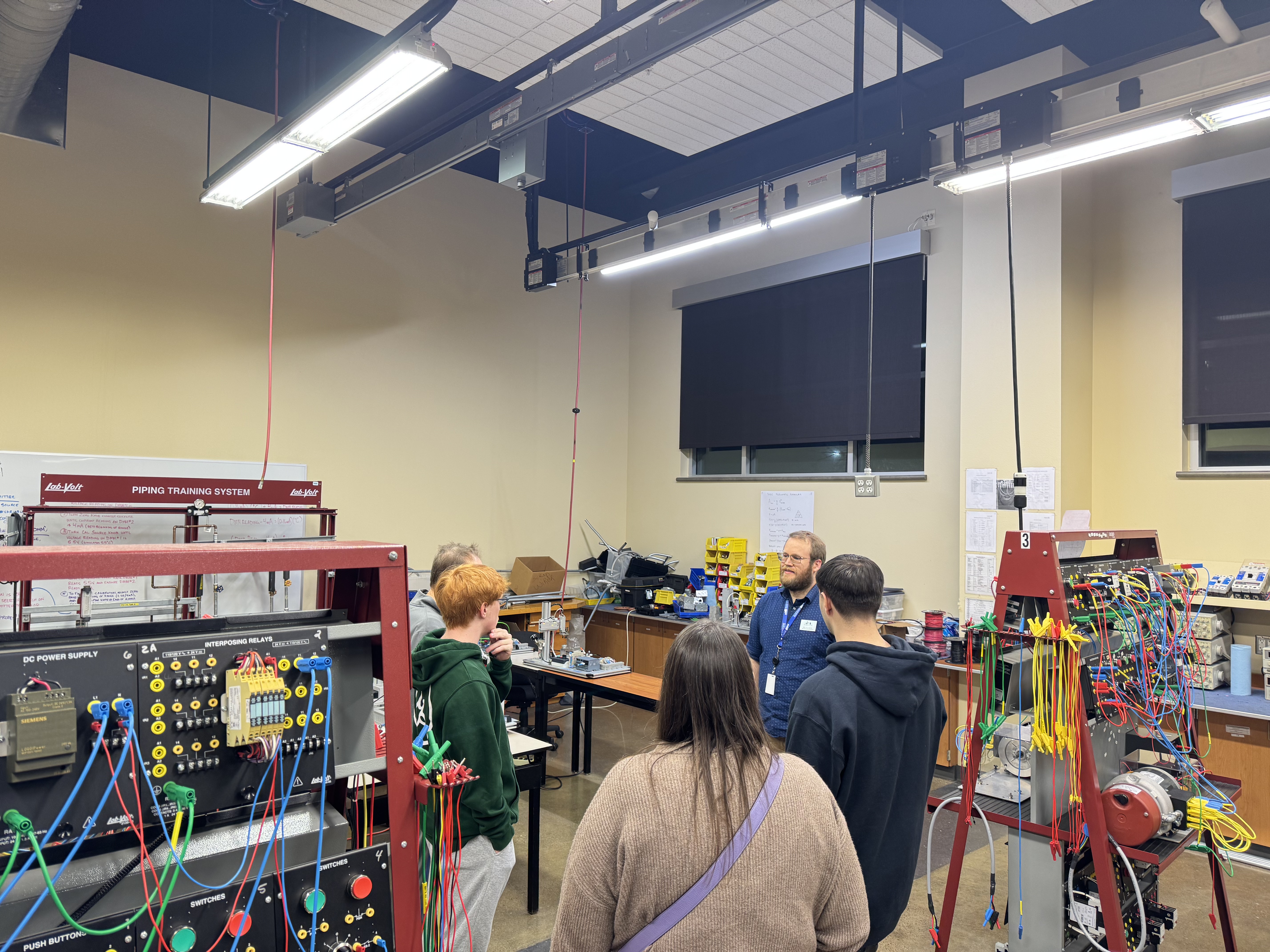 Students standing in Mechatronics lab and speaking with instructor