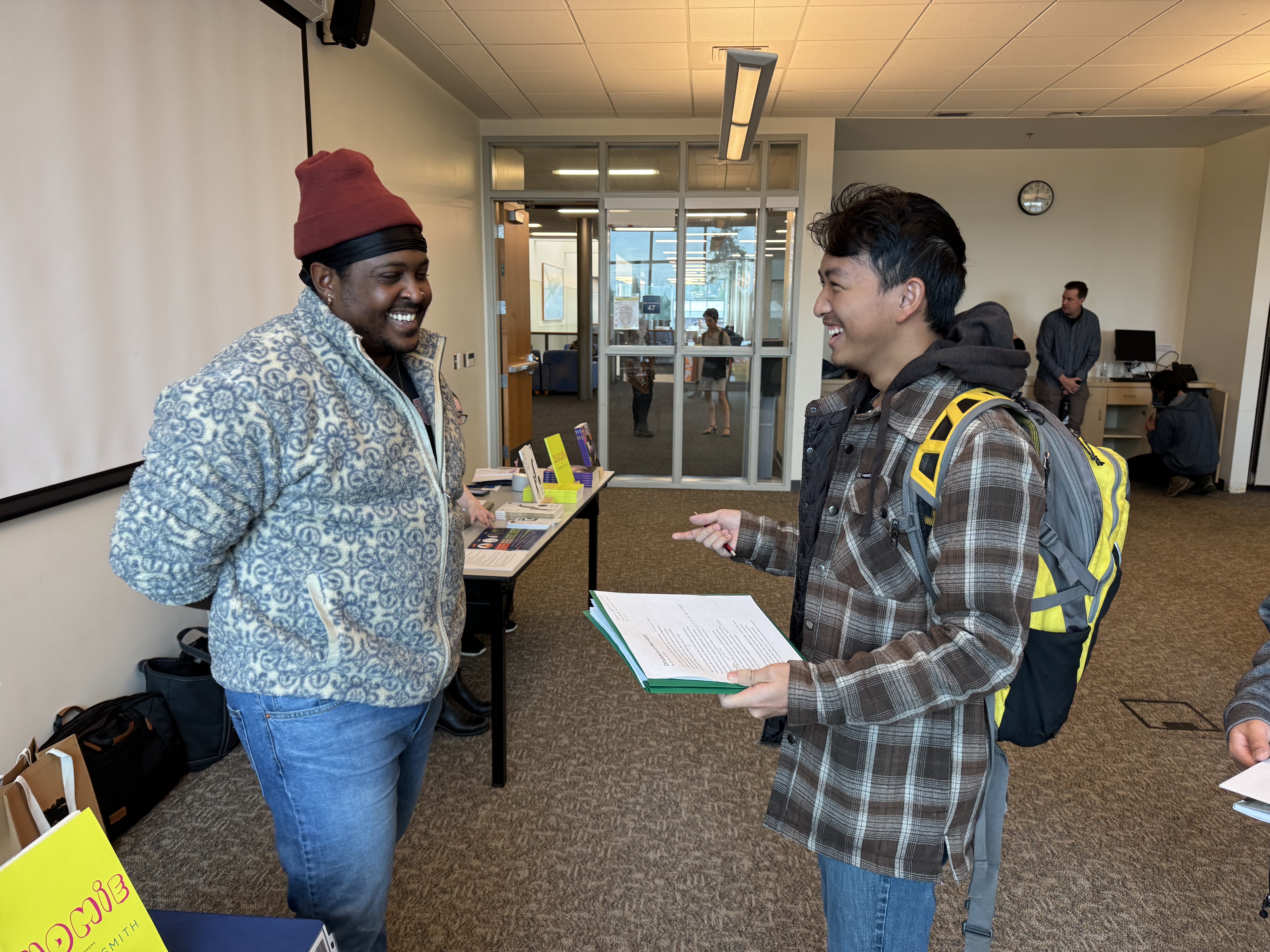 Poet Danez Smith laughing with a student
