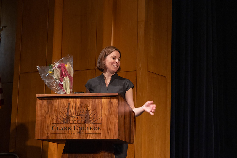 Student holding bouquet of flowers and standing at a podium
