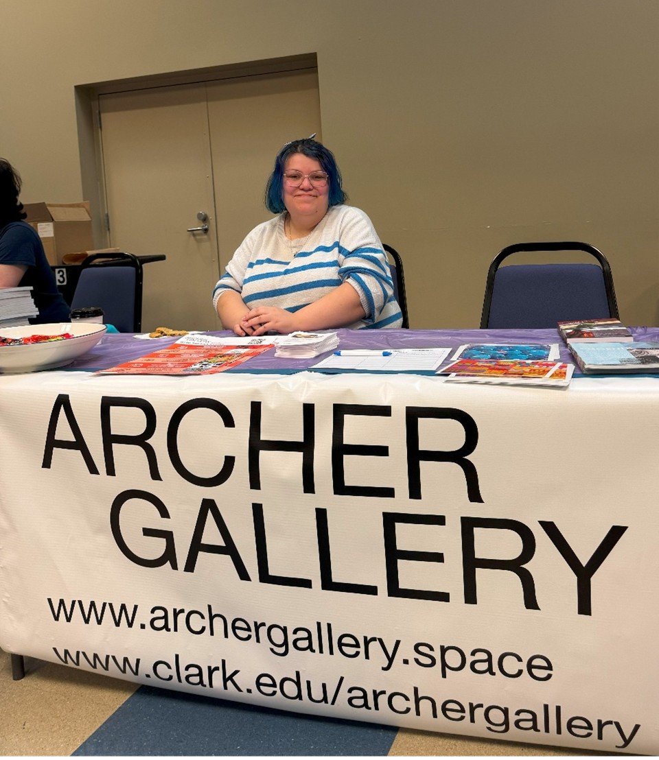 Student and assistant at the Archer Gallery, Faith, behind a table for the gallery