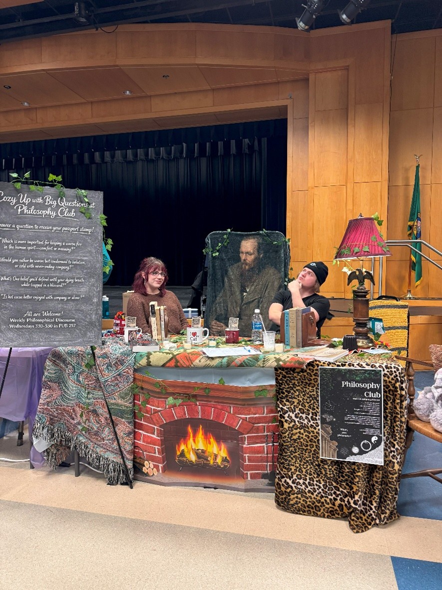 Students sit behind a decorated table for the Philosophy Club