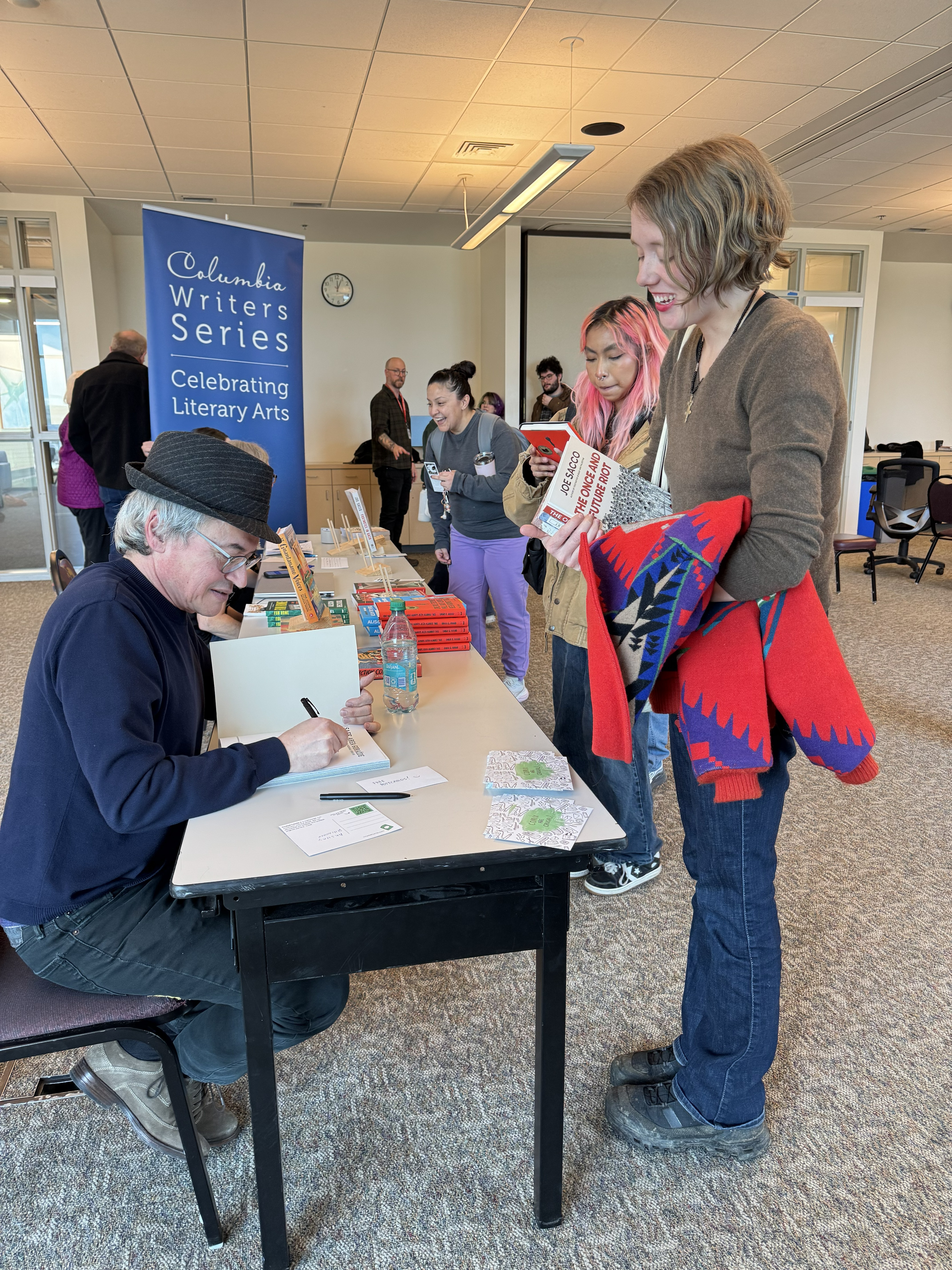Joe Sacco autographing book for event participant