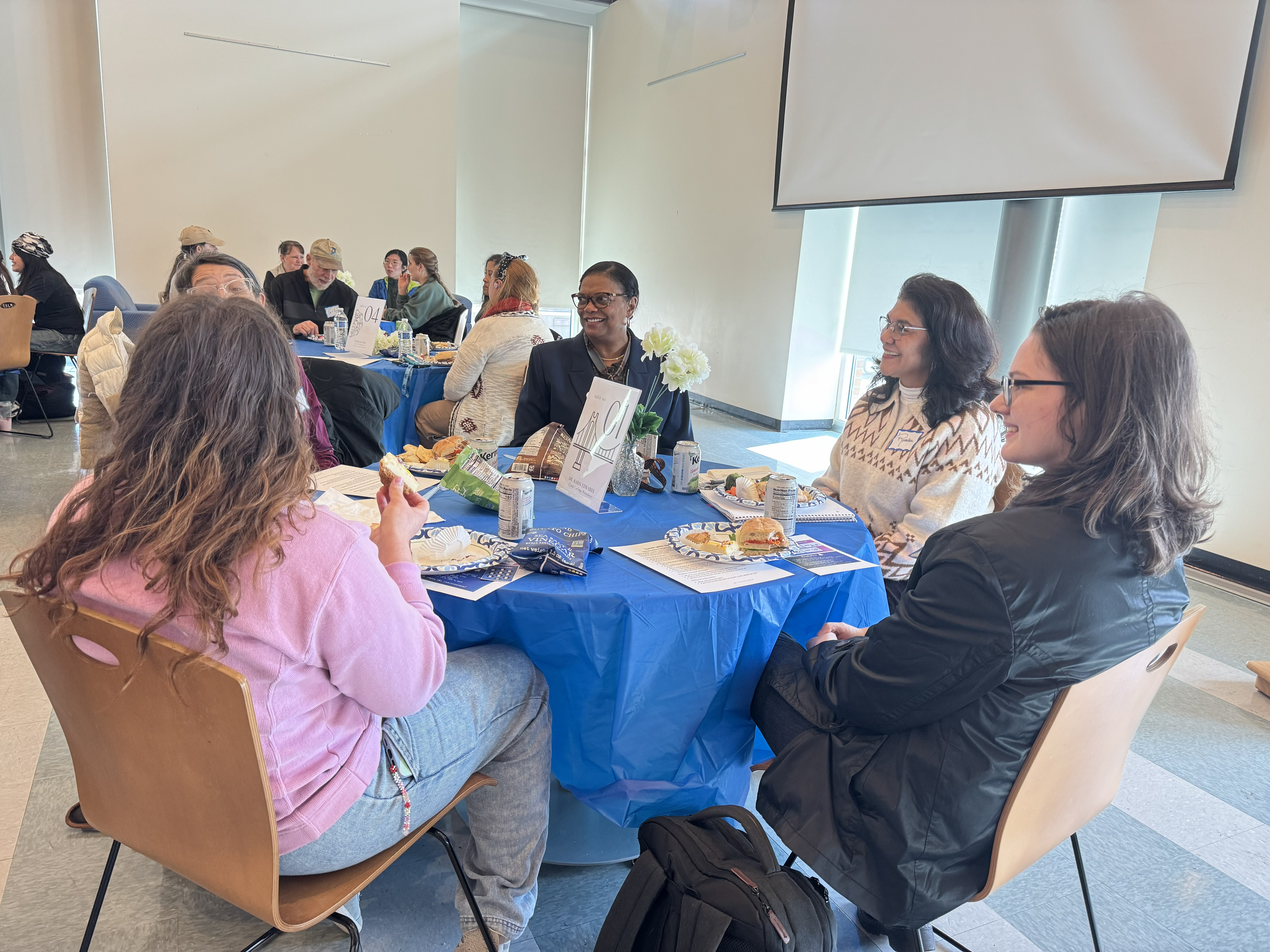 Dr. Karin Edwards laughing with students at a table