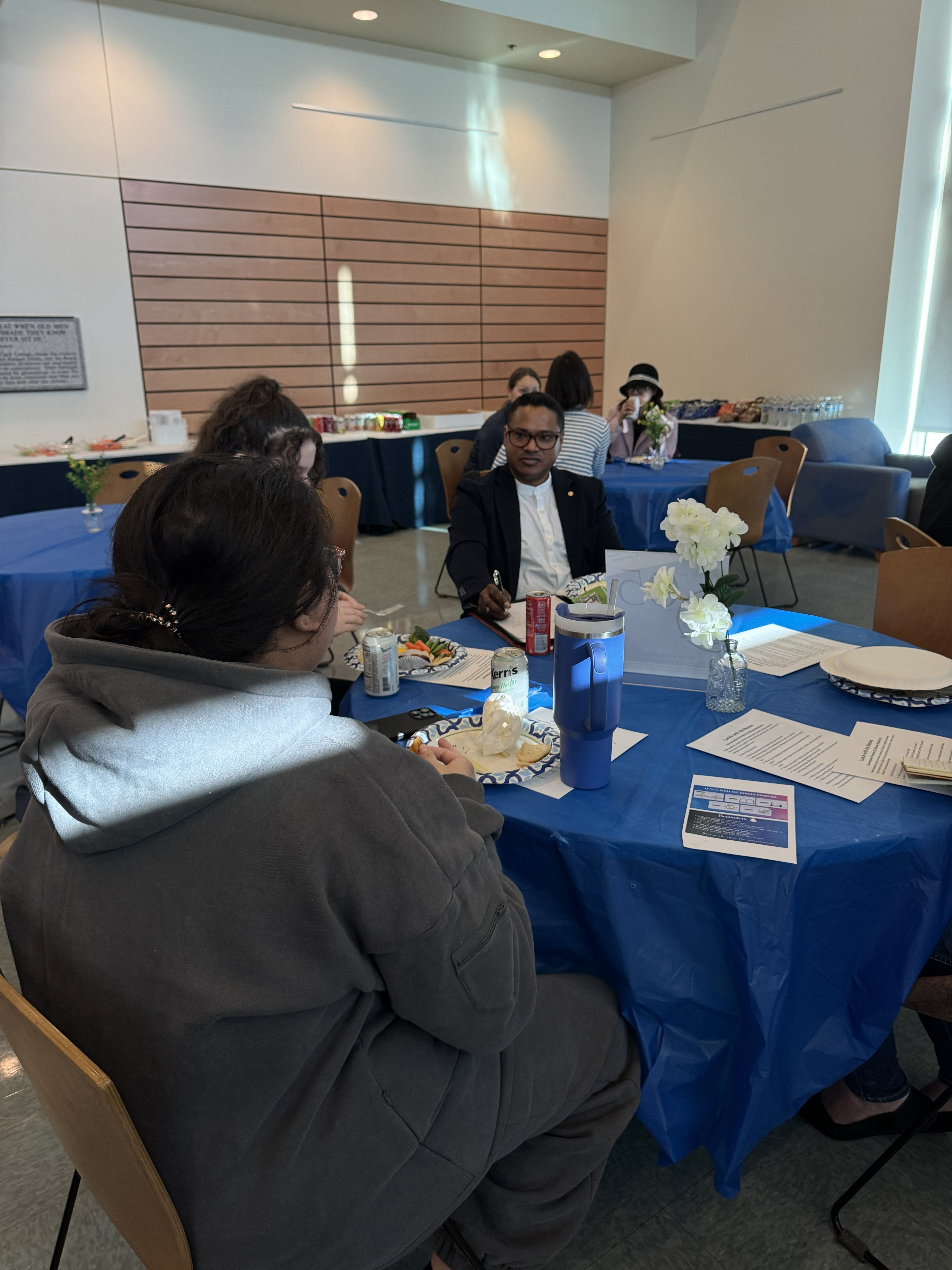 Sudha Frederick talks with students at a table