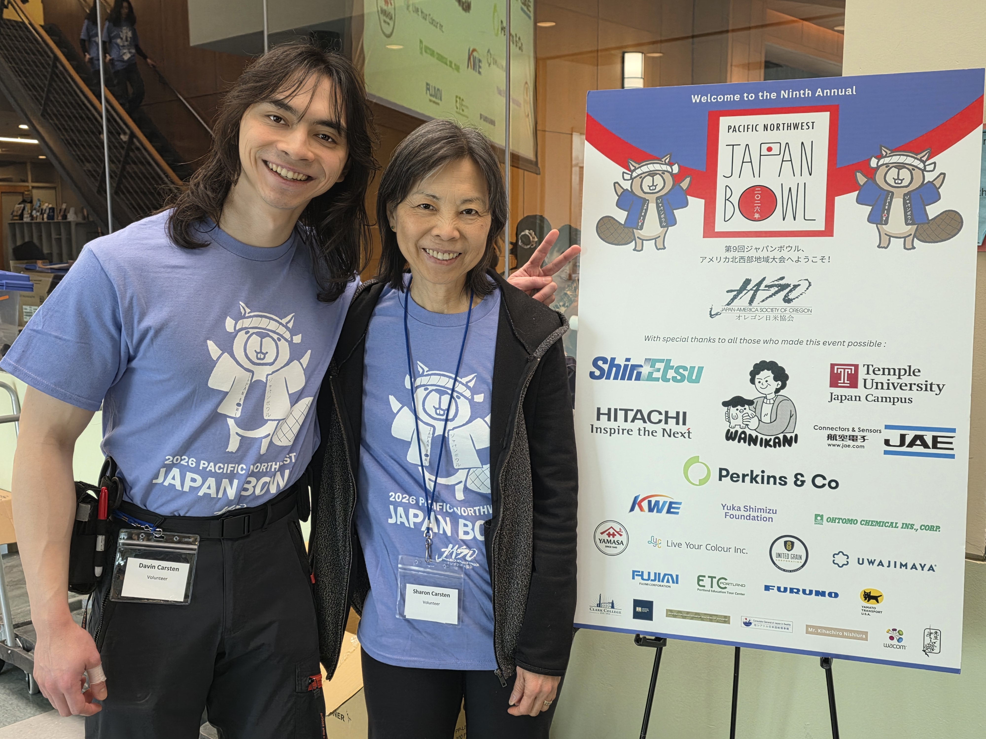 Davin and Sharon Cartsen in front of a Japan Bowl poster