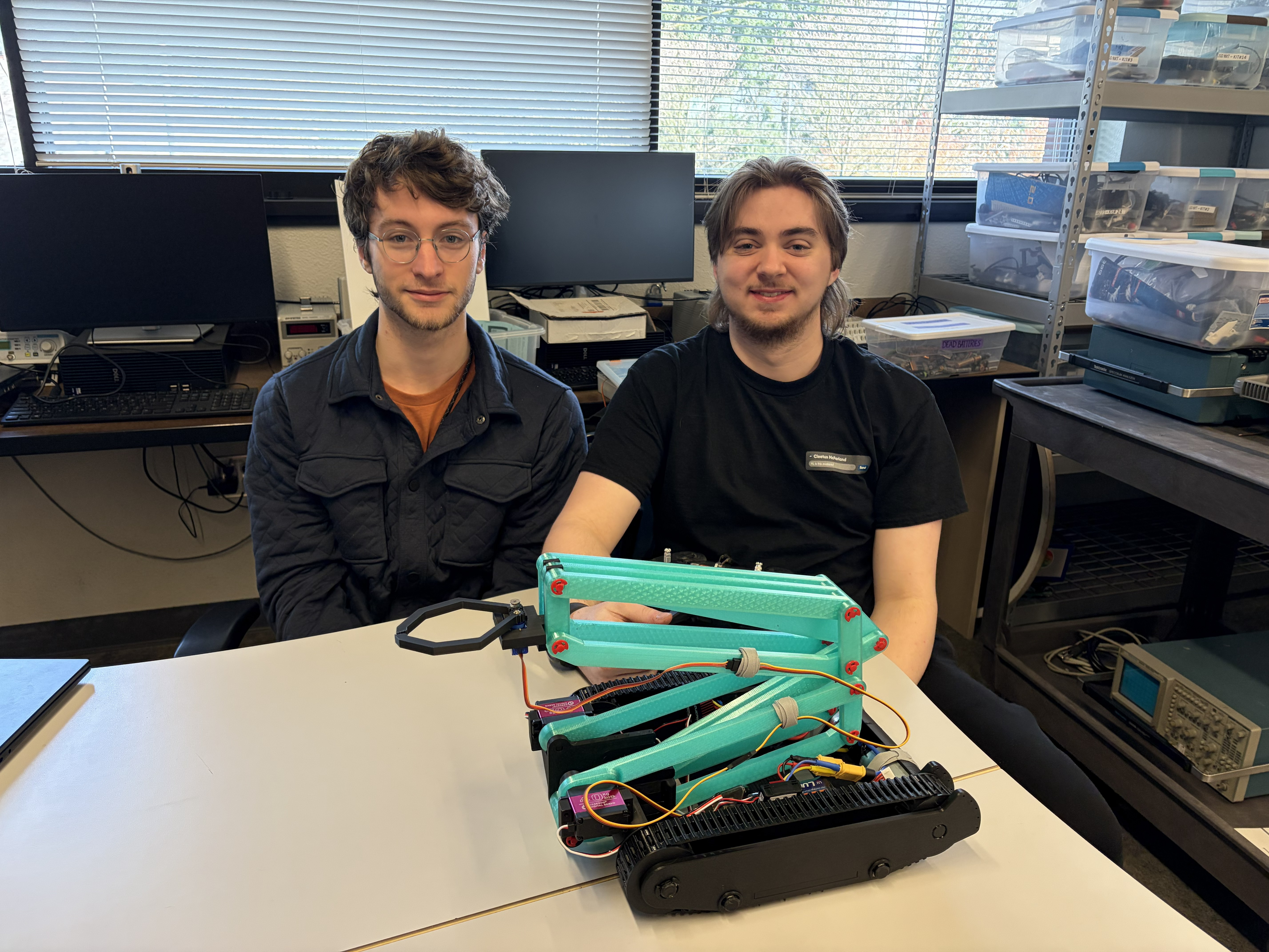 Team Pengu-Mon, Kieran and Max, sitting with a small blue robot