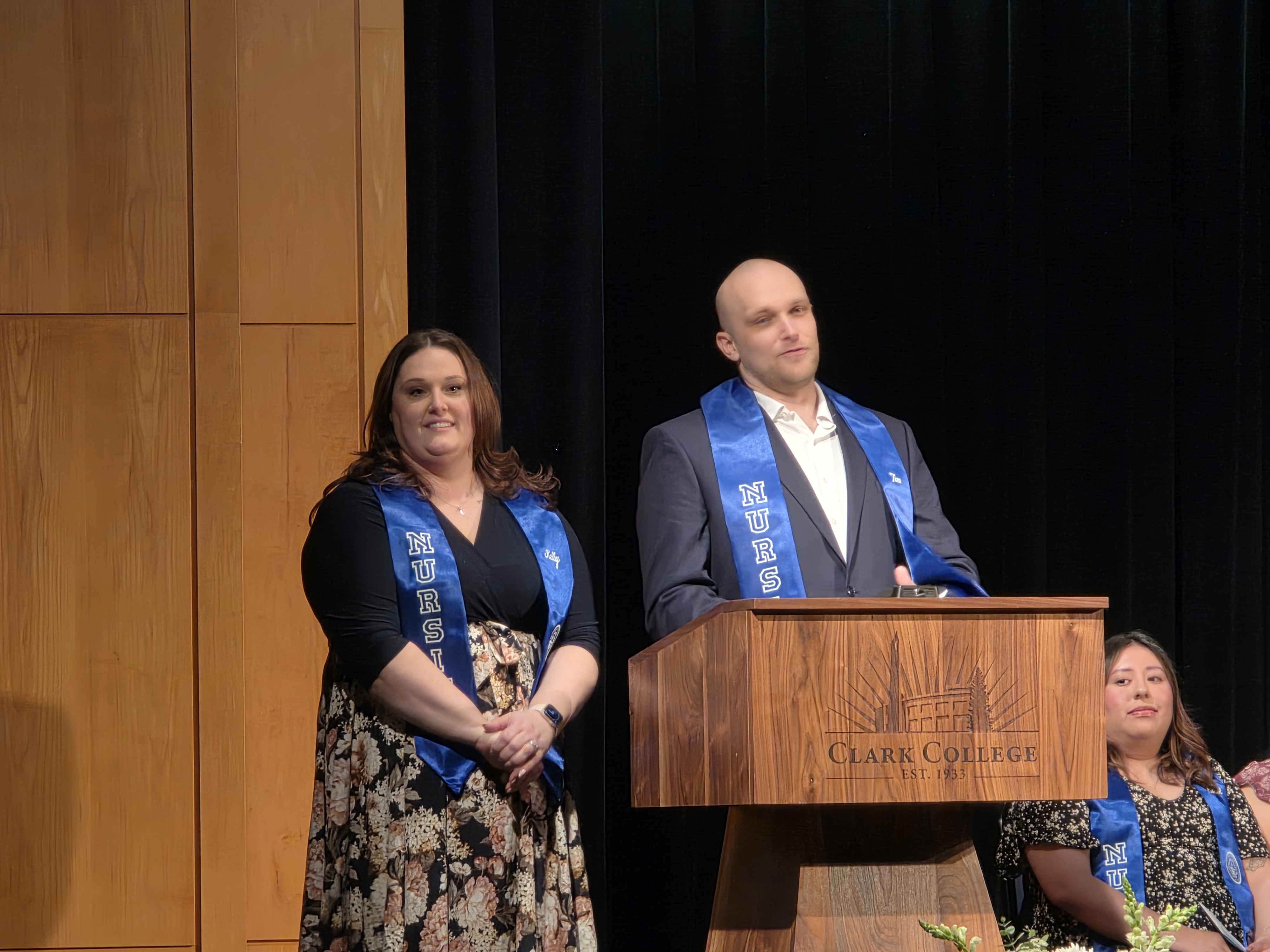 Kelly Jancki and Tim Klyuchnik on stage giving a speech