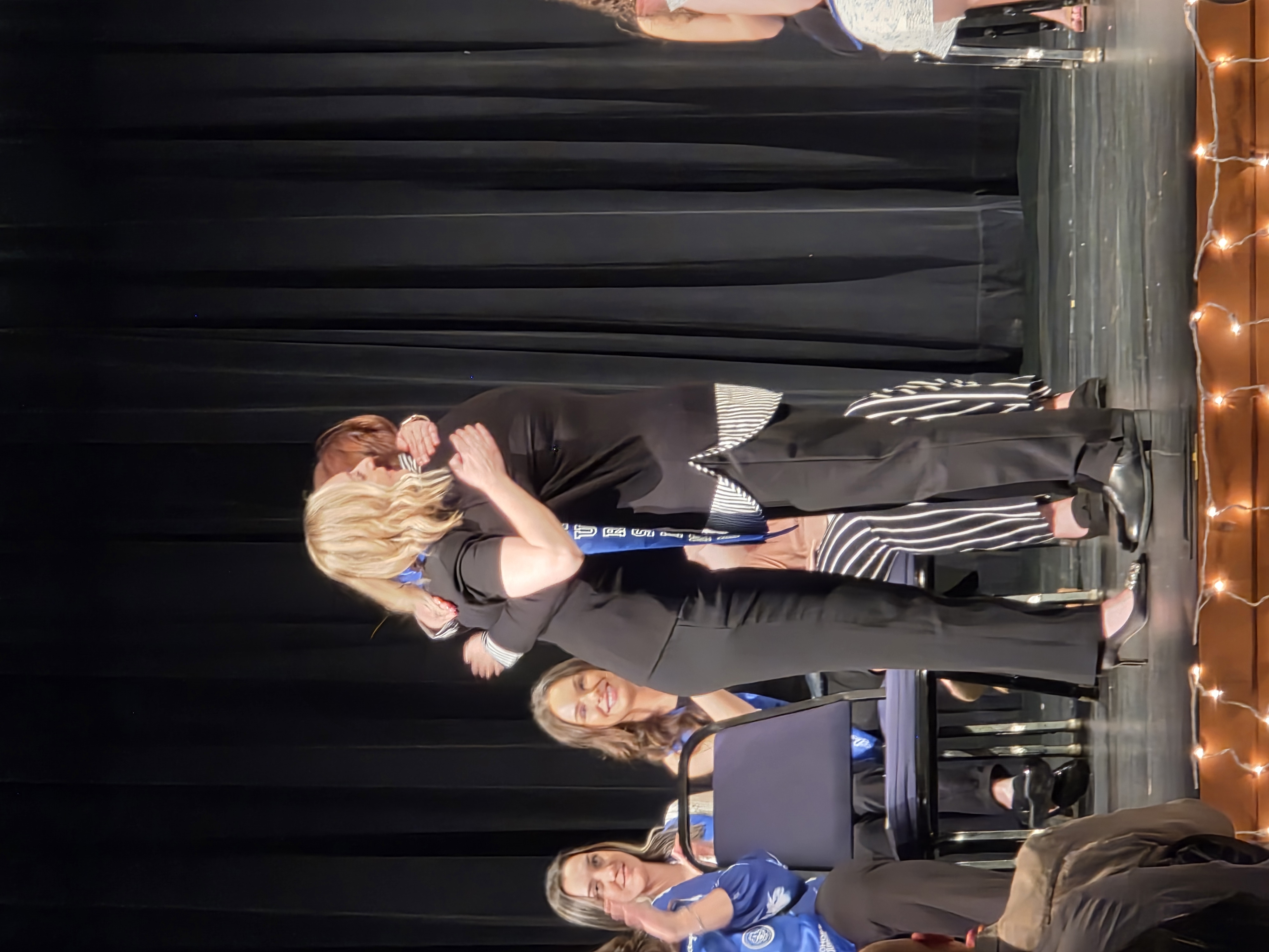 Nursing student hugging her mom on stage after receiving her nursing pin