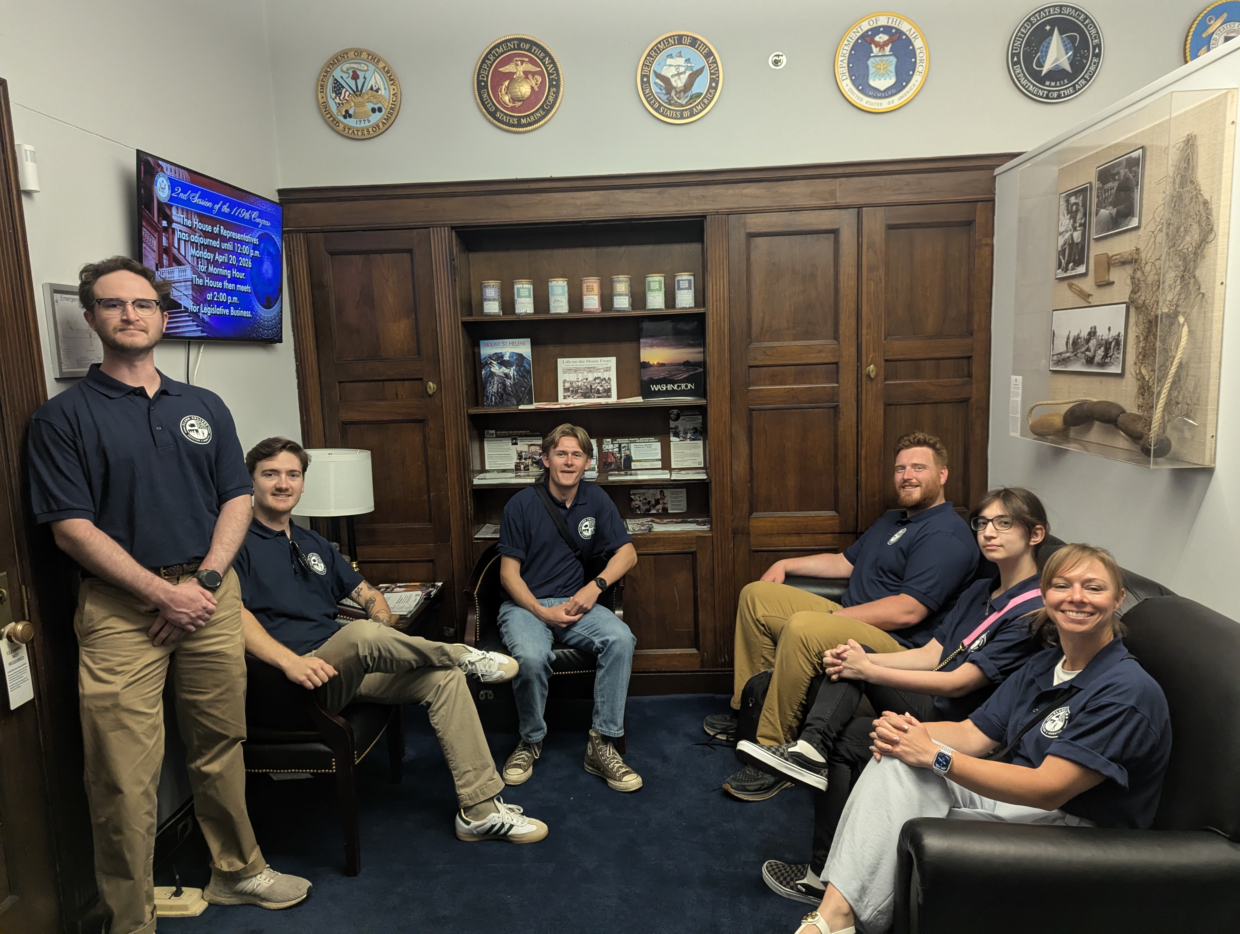 Students sitting in office surrounded by Washington state and U.S. memorabilia