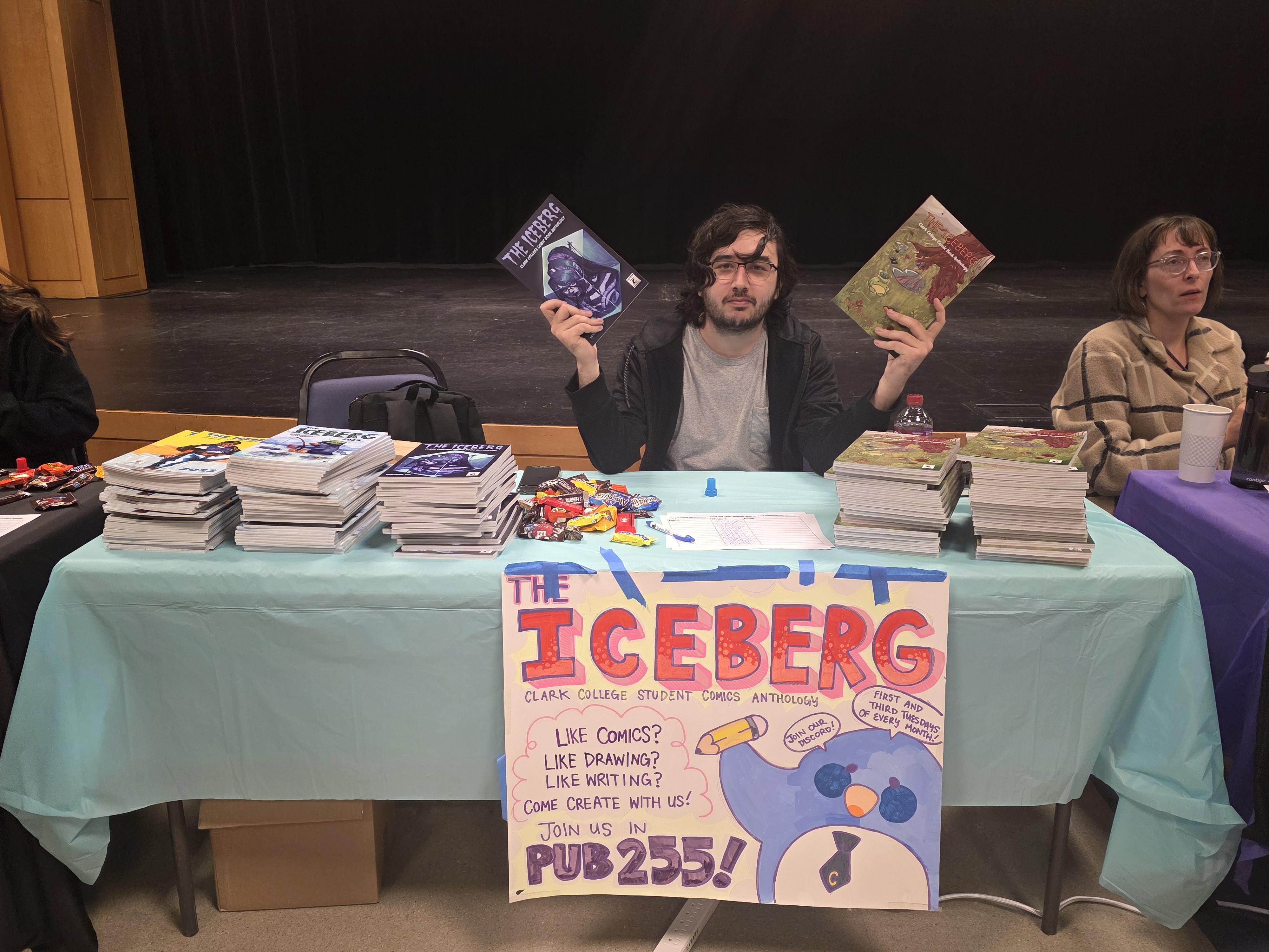 Student holding up issues of The Iceberg