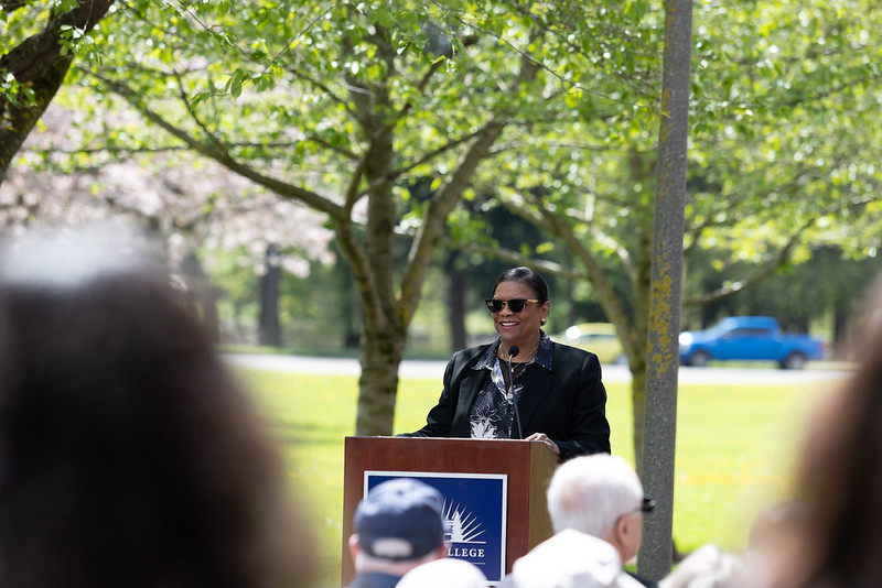 Dr. Edwards stands at a podium in the Friendship Garden