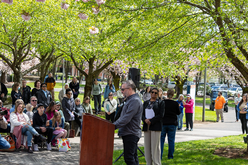 Council member Erik Paulsen at a podium under the cherry trees