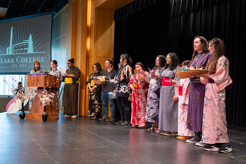 Students dressed in kimonos holding paper cranes