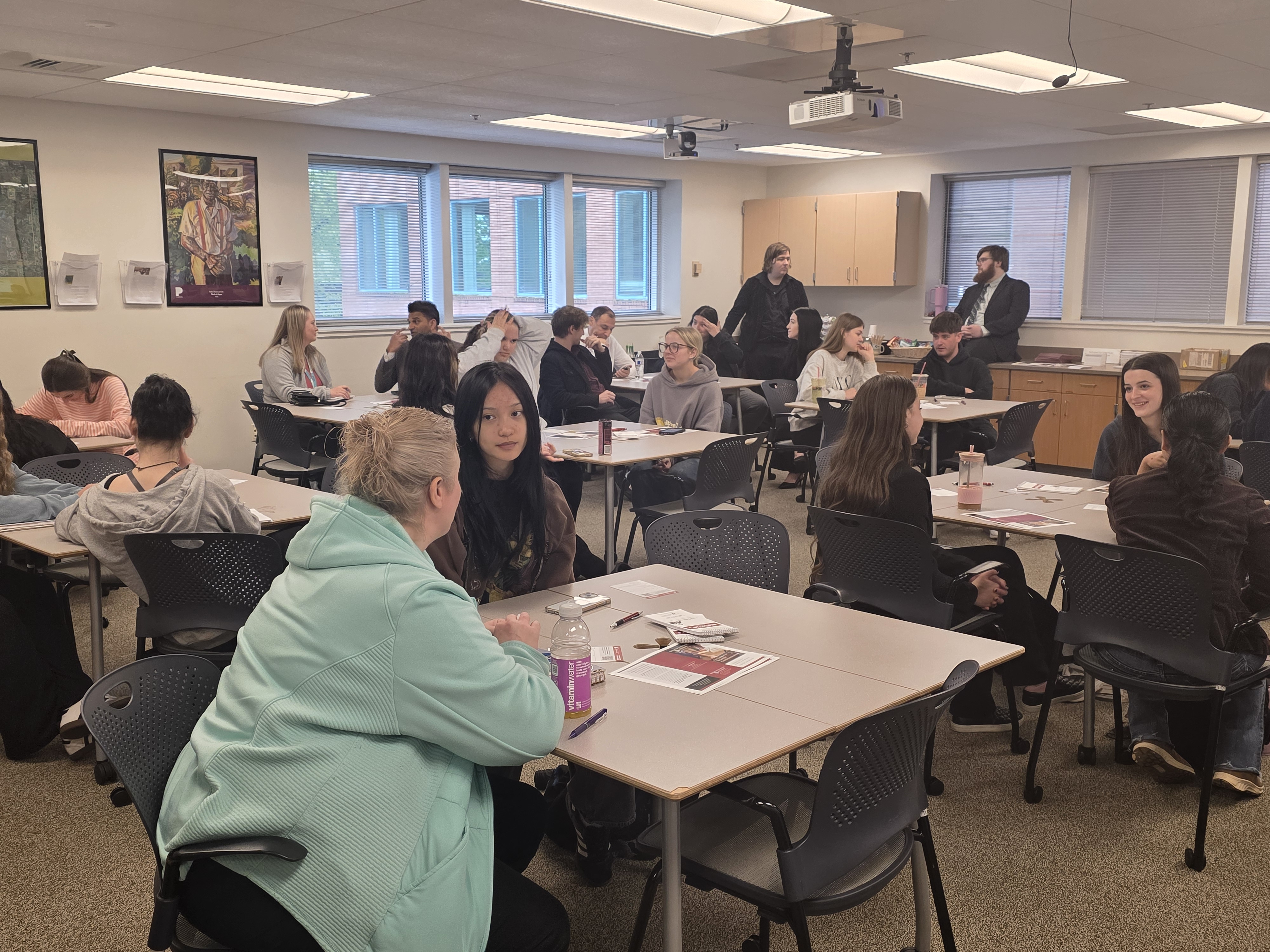 Classroom of students engaging with each other in tablegroups