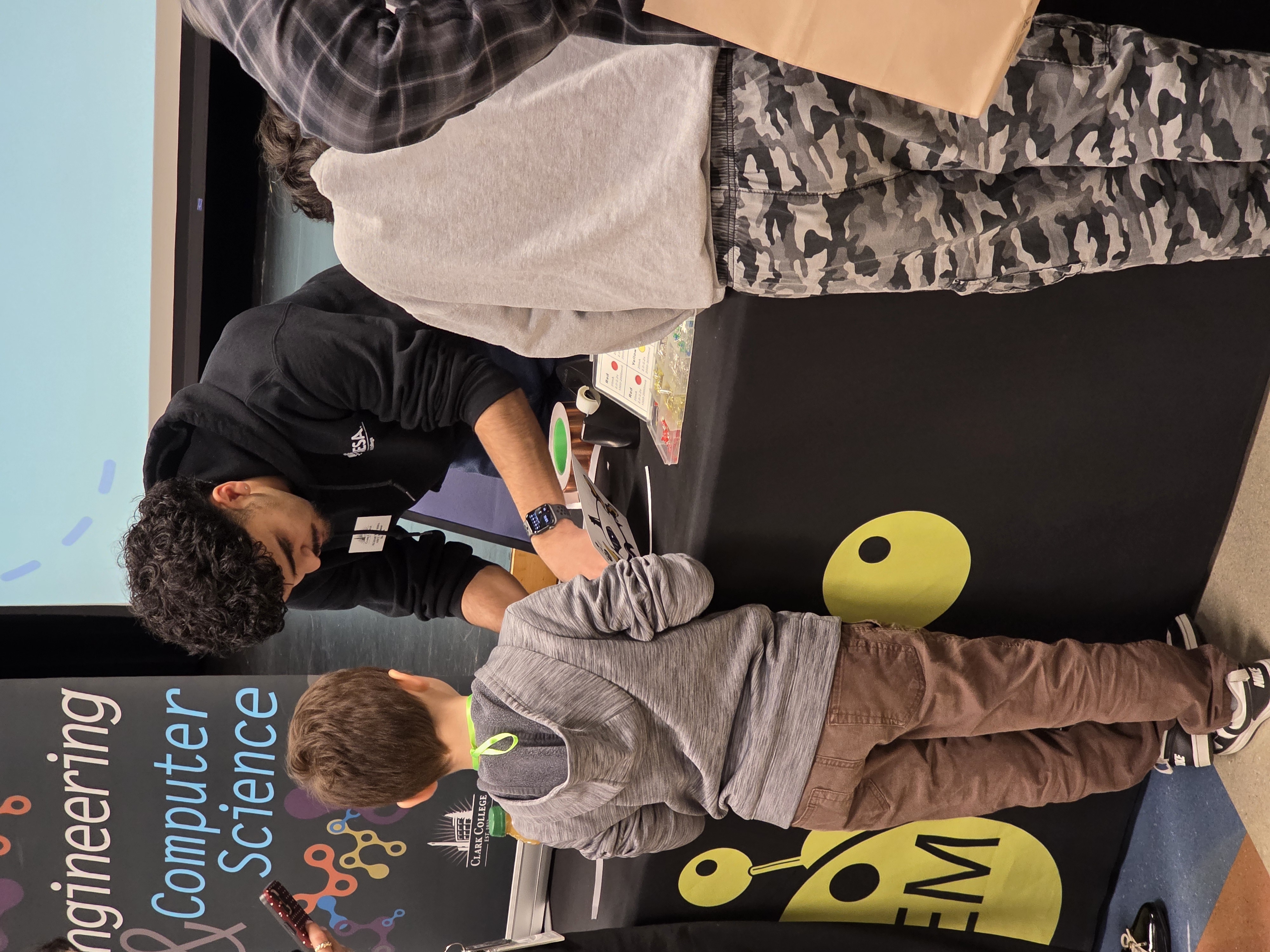 ASCC President helps a child with a STEM experiment