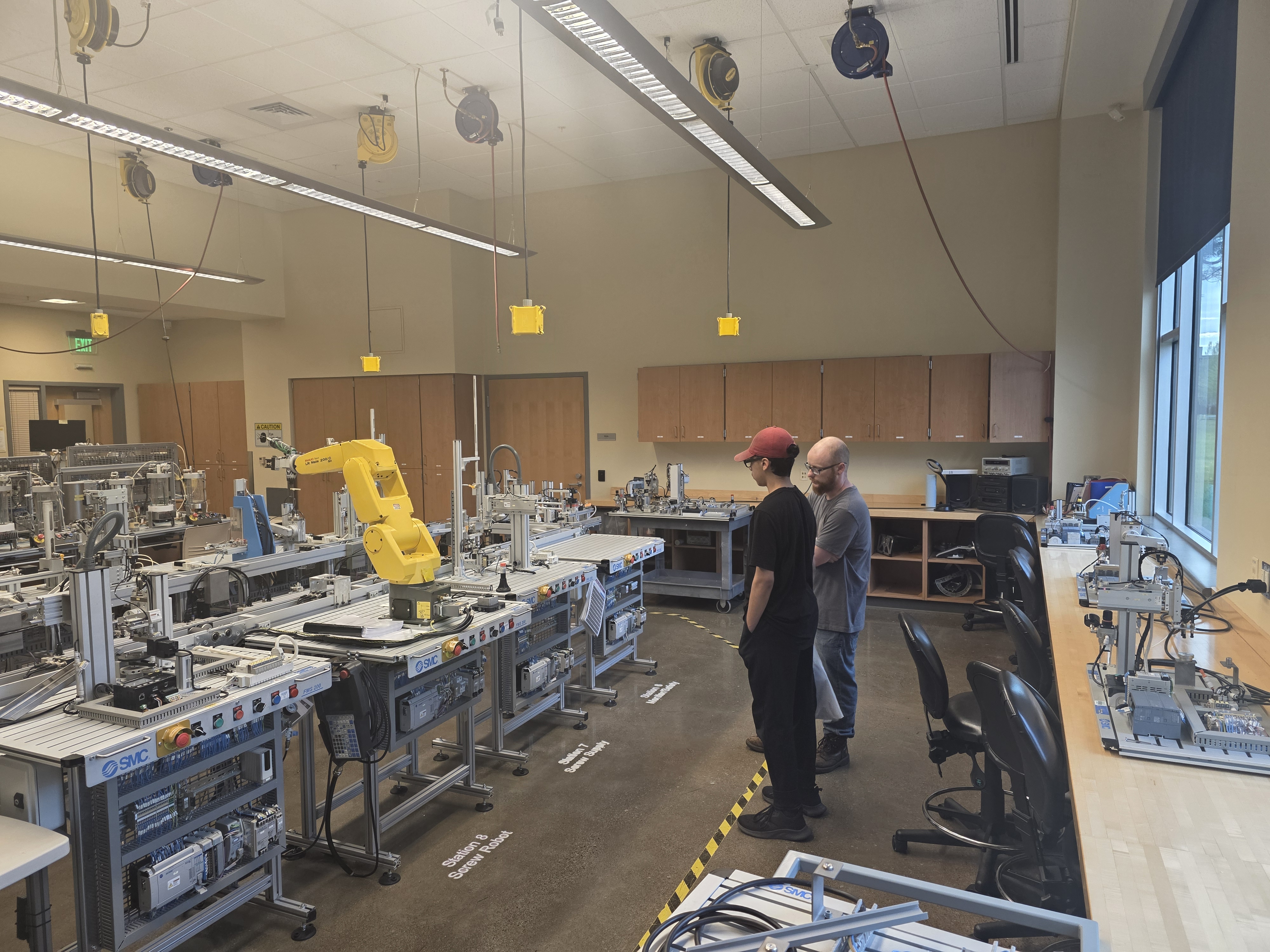 Mechatronics professor and high school student in conversation in mechatronics lab