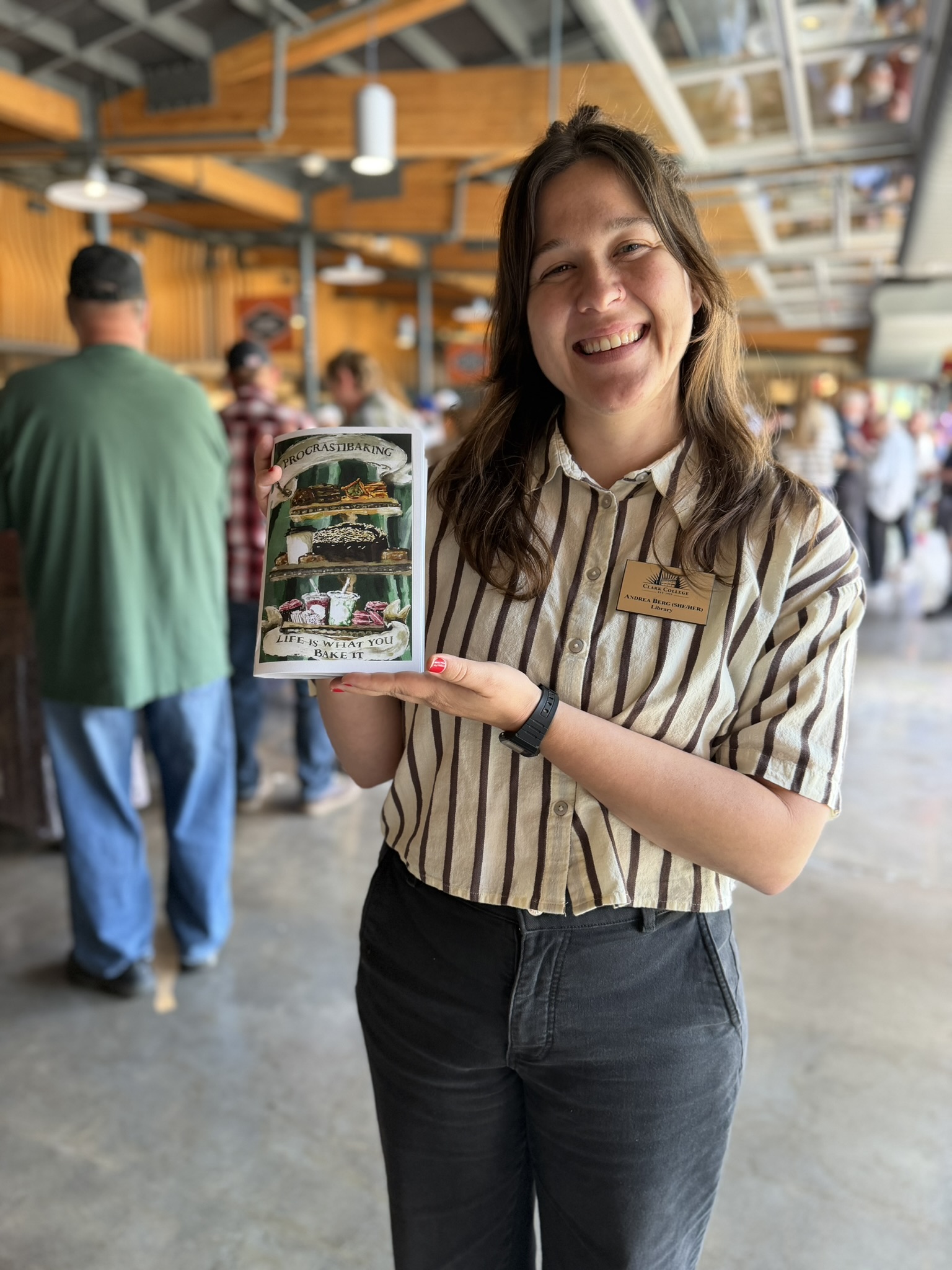 Library staff member holds up baking students' zine