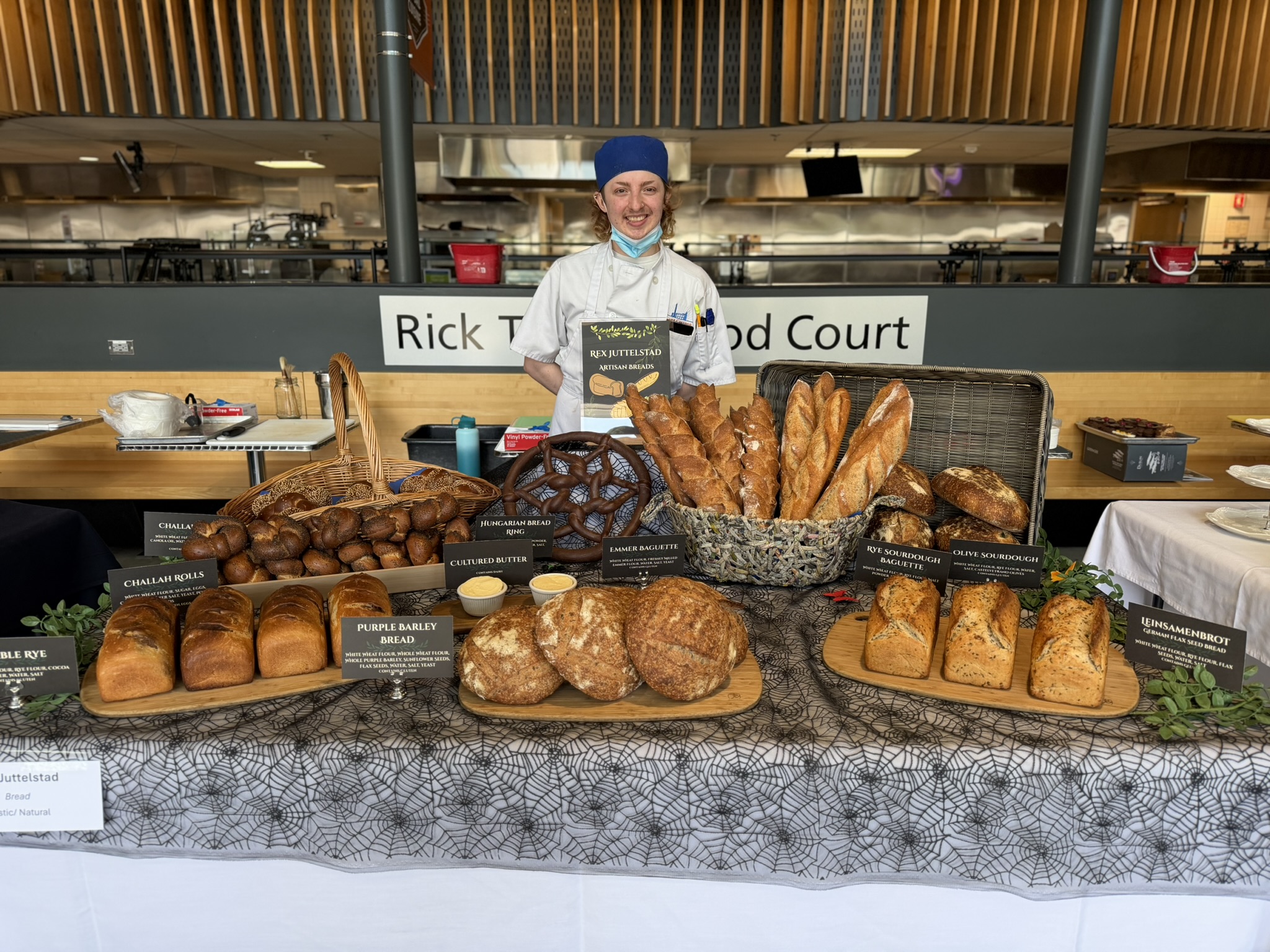 Baking student behind his table of bread