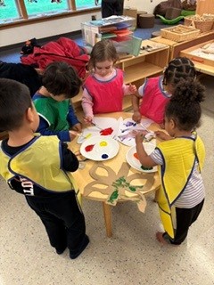 Children wearing aprons at a table doing crafts
