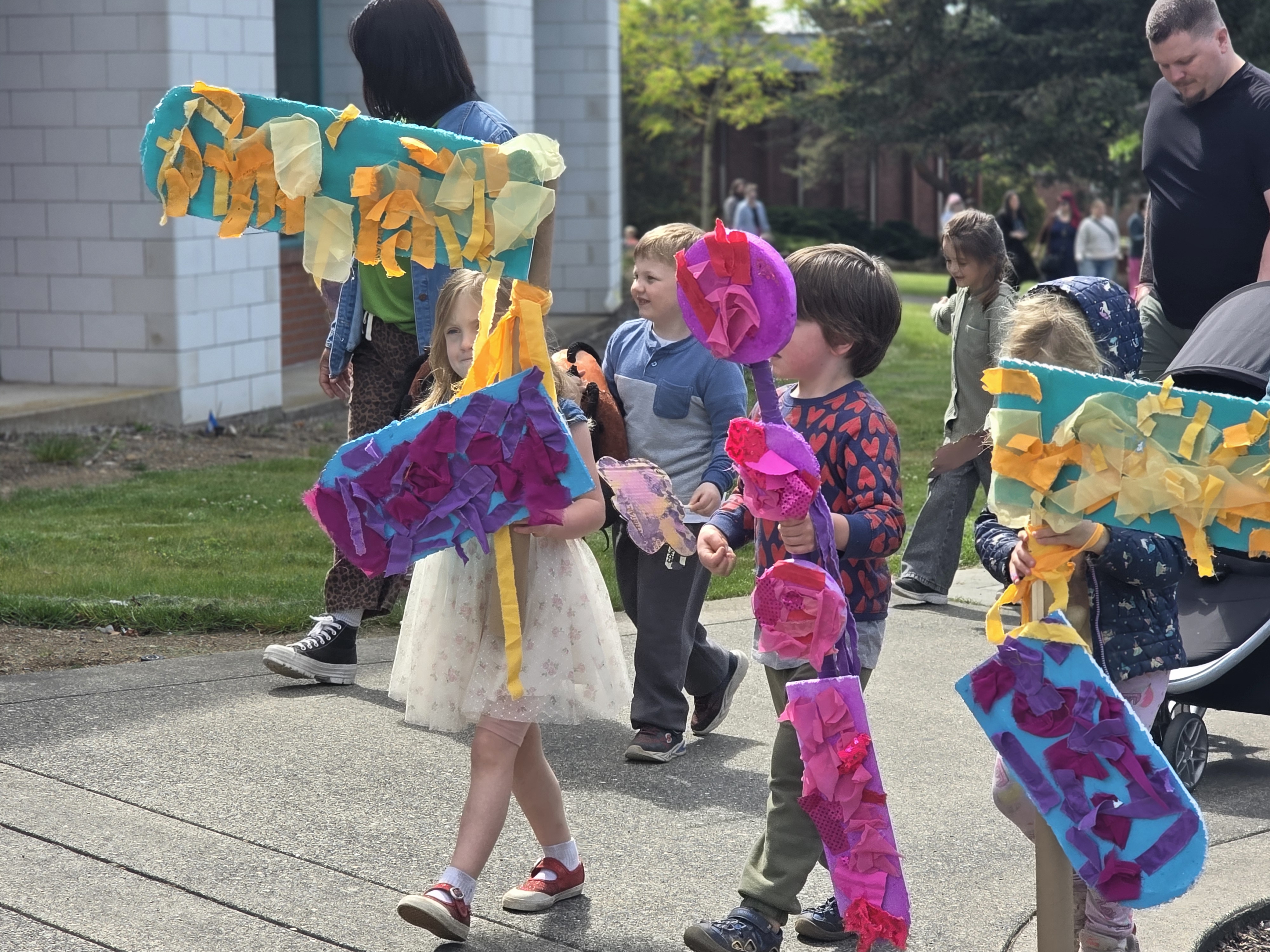 Children marching with props in puppet parade