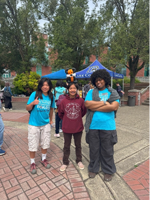 APB members Sophia Hao and Nia Matthews stand alongside a student with a balloon fox