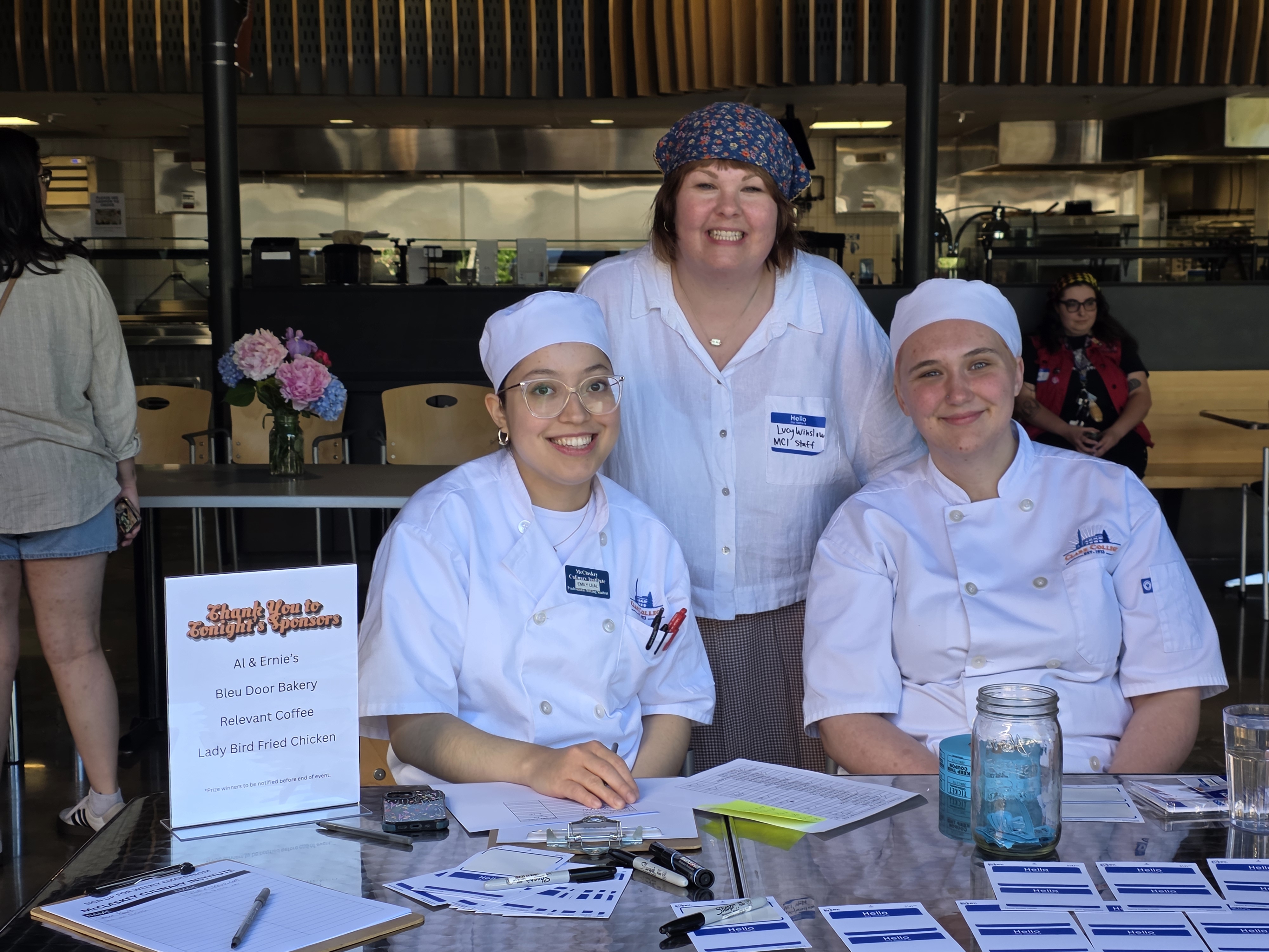 Lucy stands next to culinary students at the event's check-in table