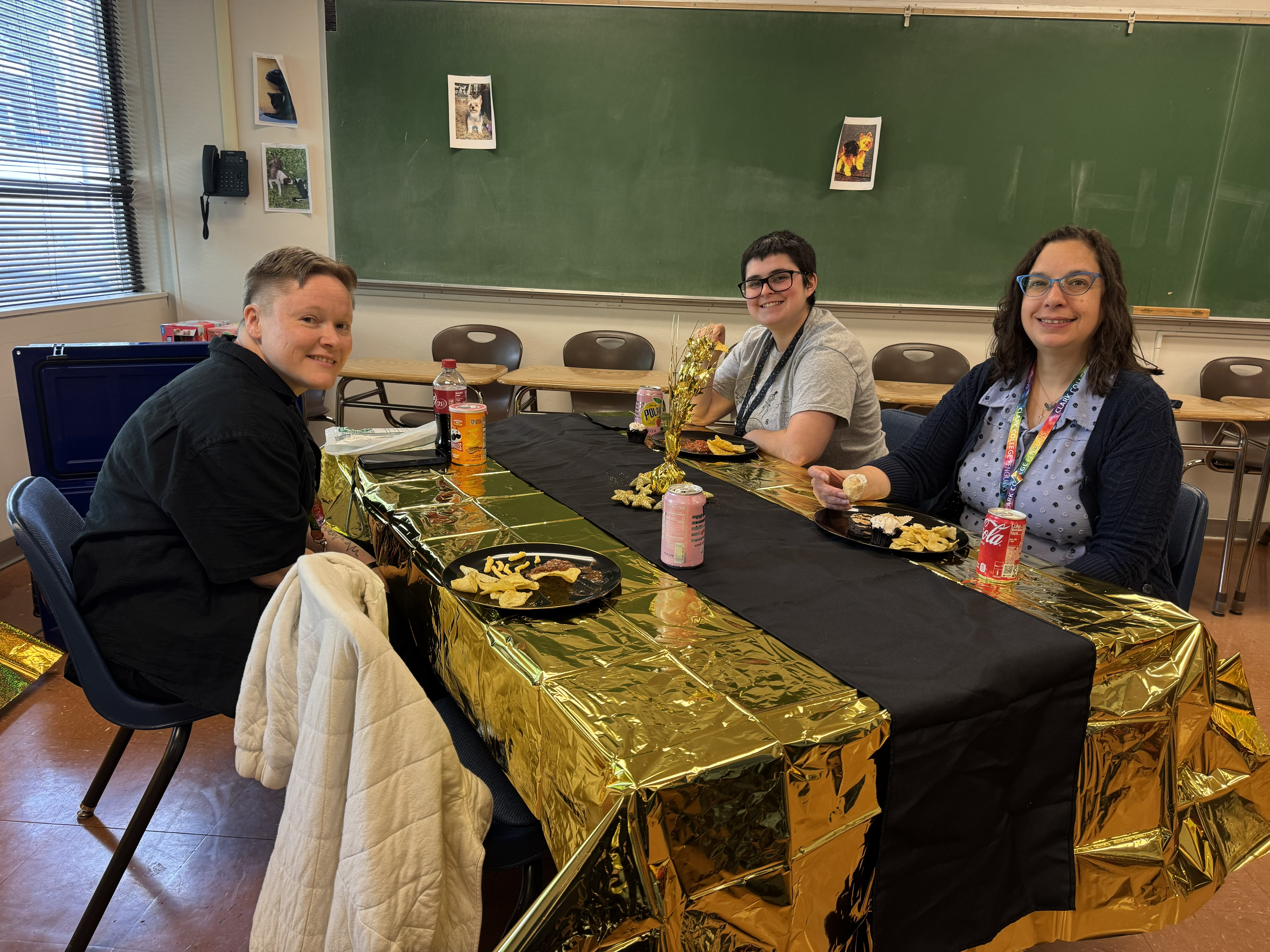 Three people smiling and sitting at a table