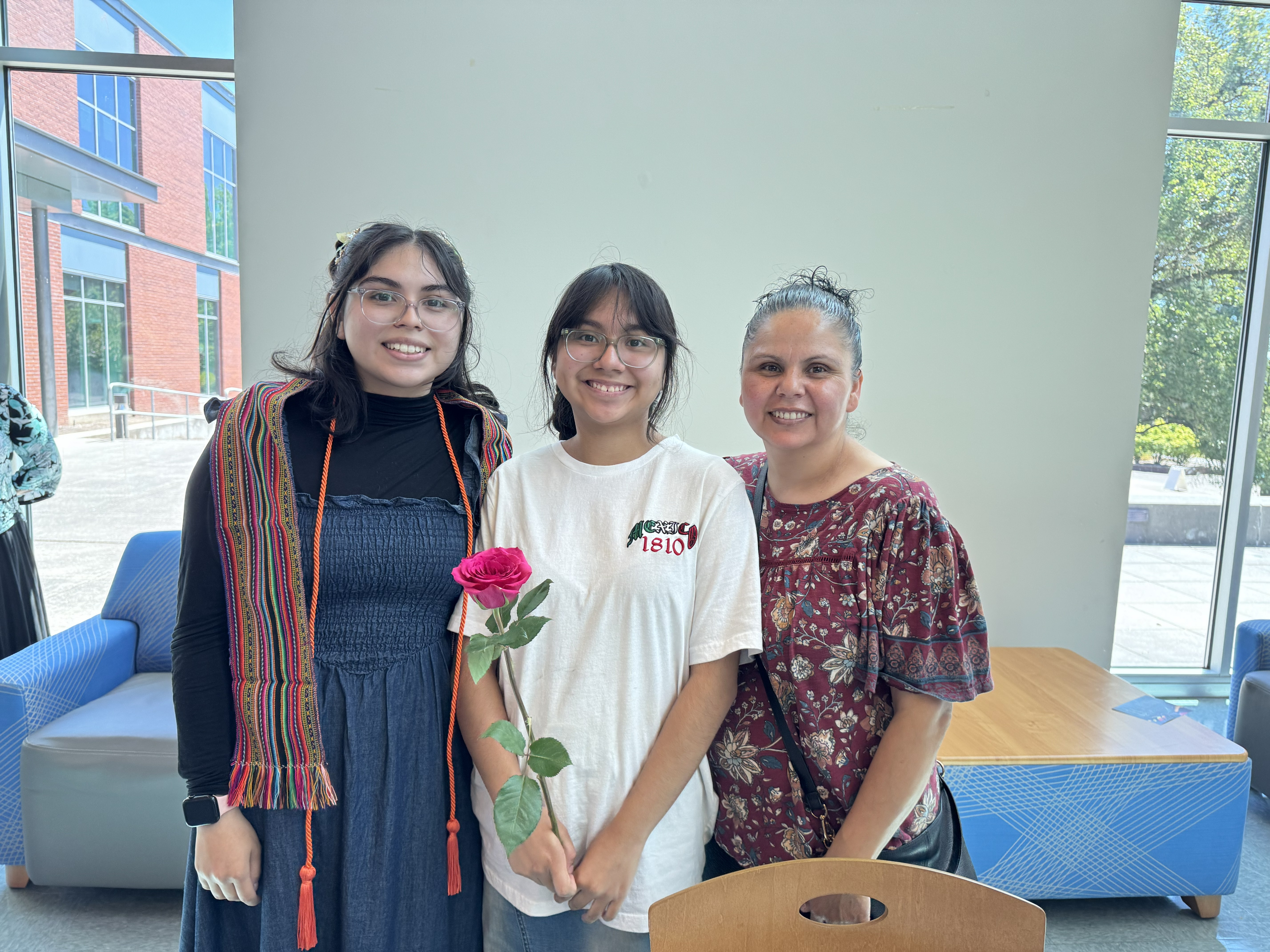 Diversity Center graduate with family and rose