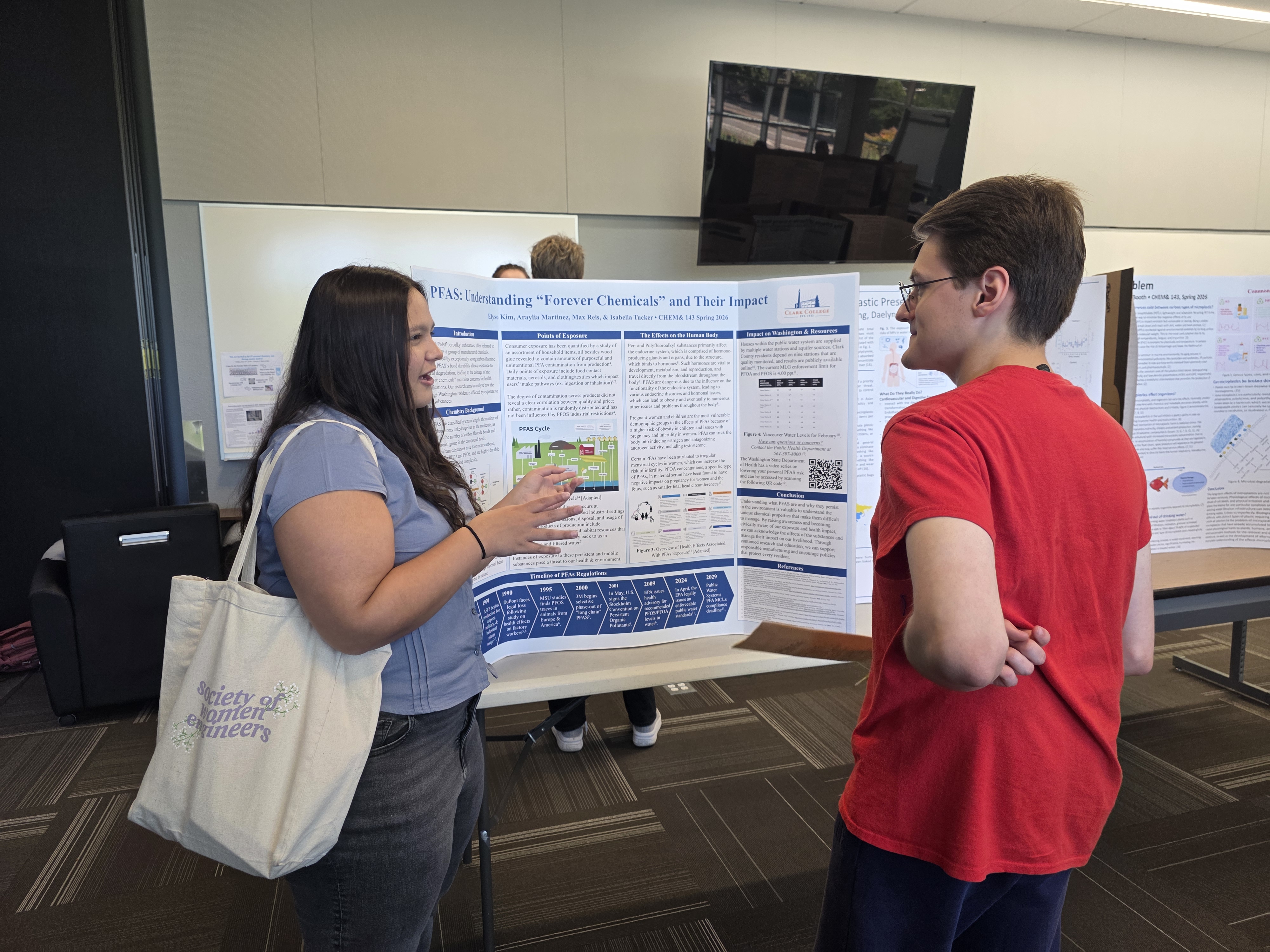 Chemistry student discusses her poster with an event attendee