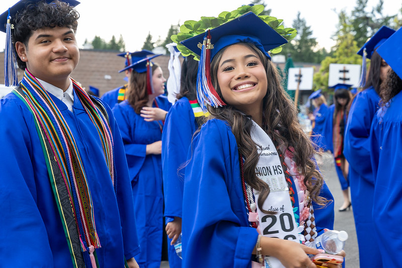 Grads smile at the camera before entering the ampitheatre