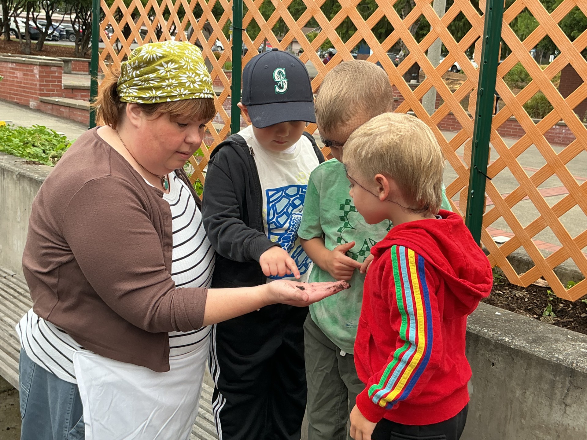 Lucy Winslow shows a worm in her hand to a small group of children.