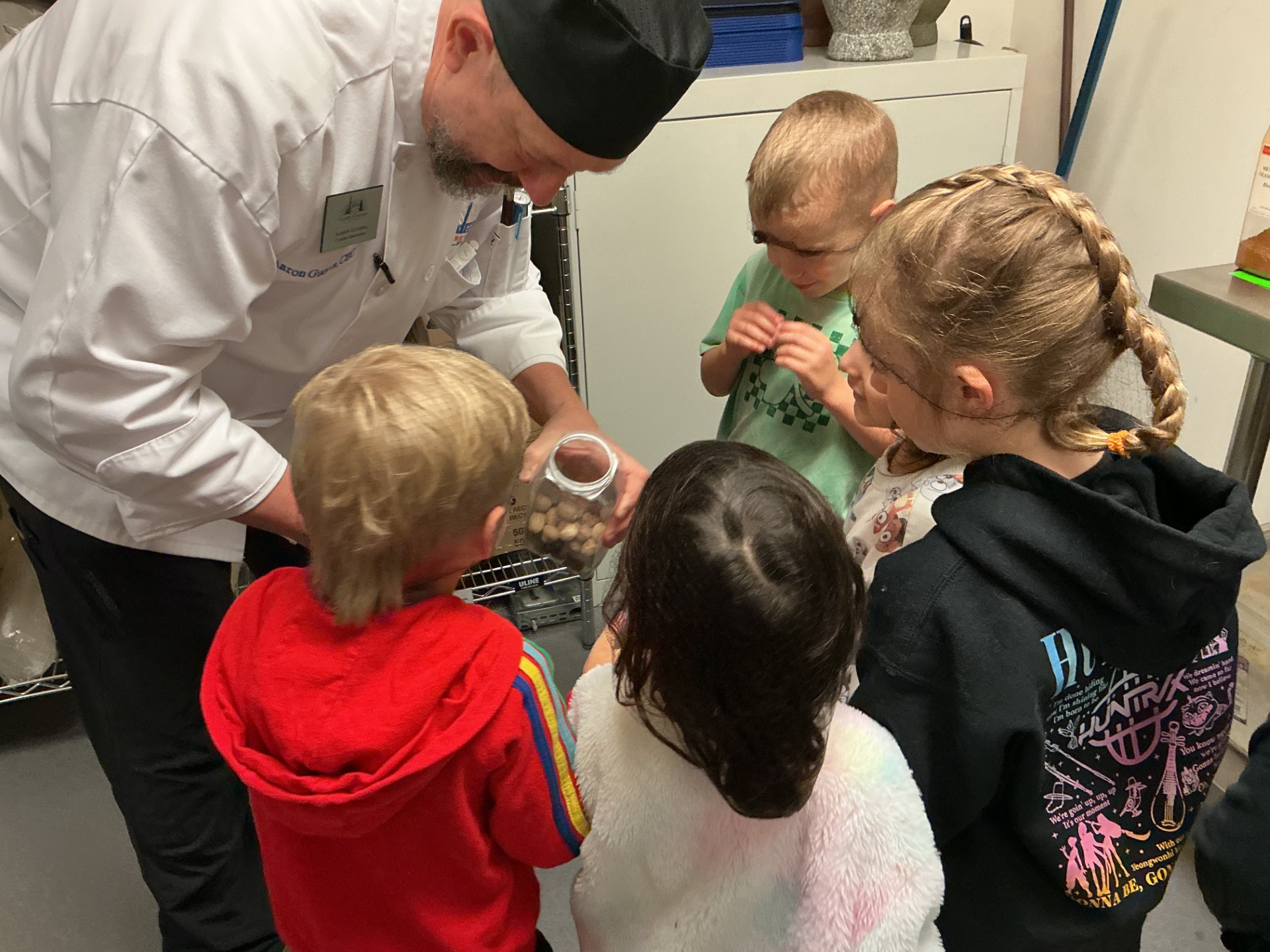 Chef Aaron shows group of children a spice from a jar