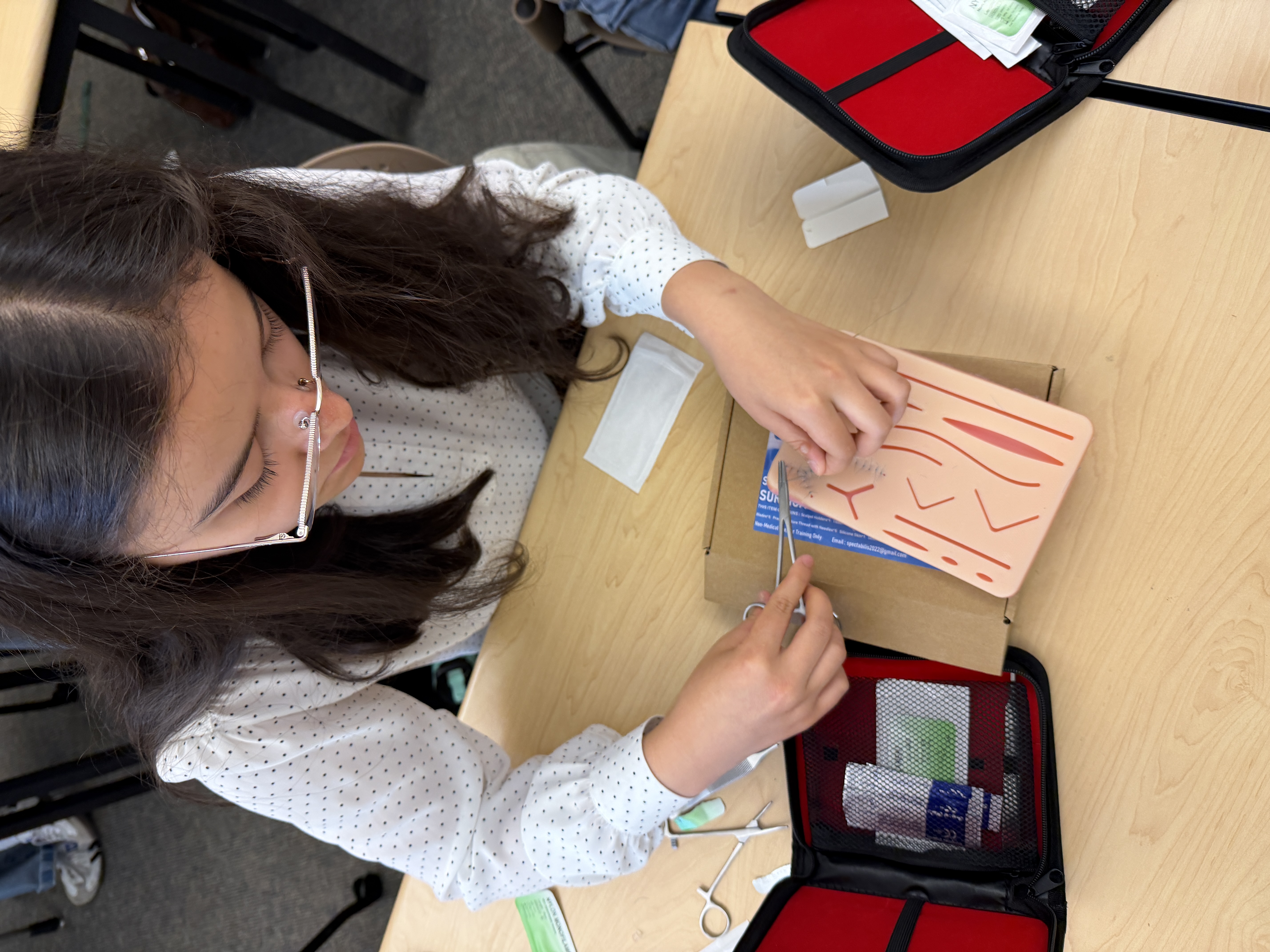 Student practices removing sutures on a dummy