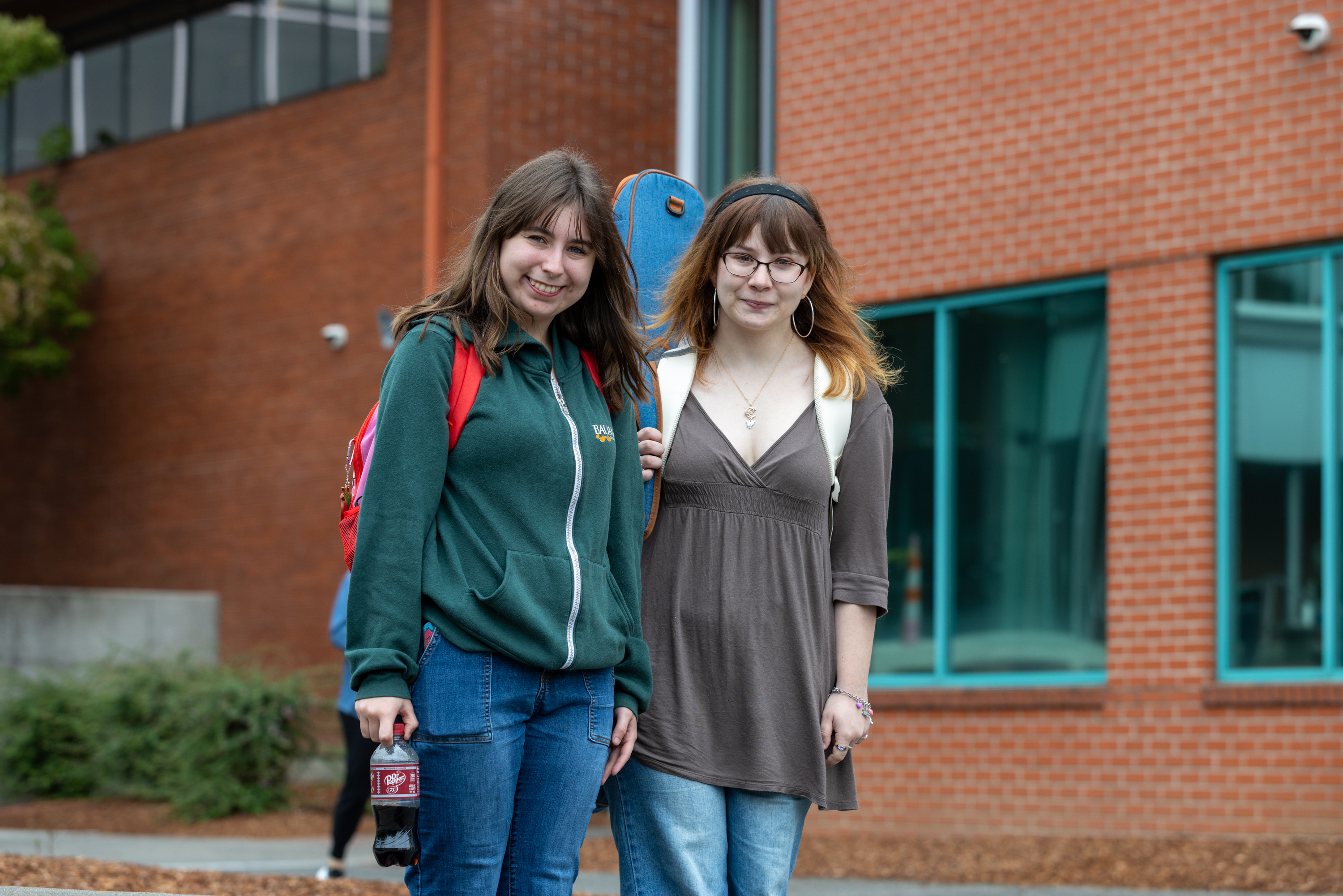 Students stand smiling outside