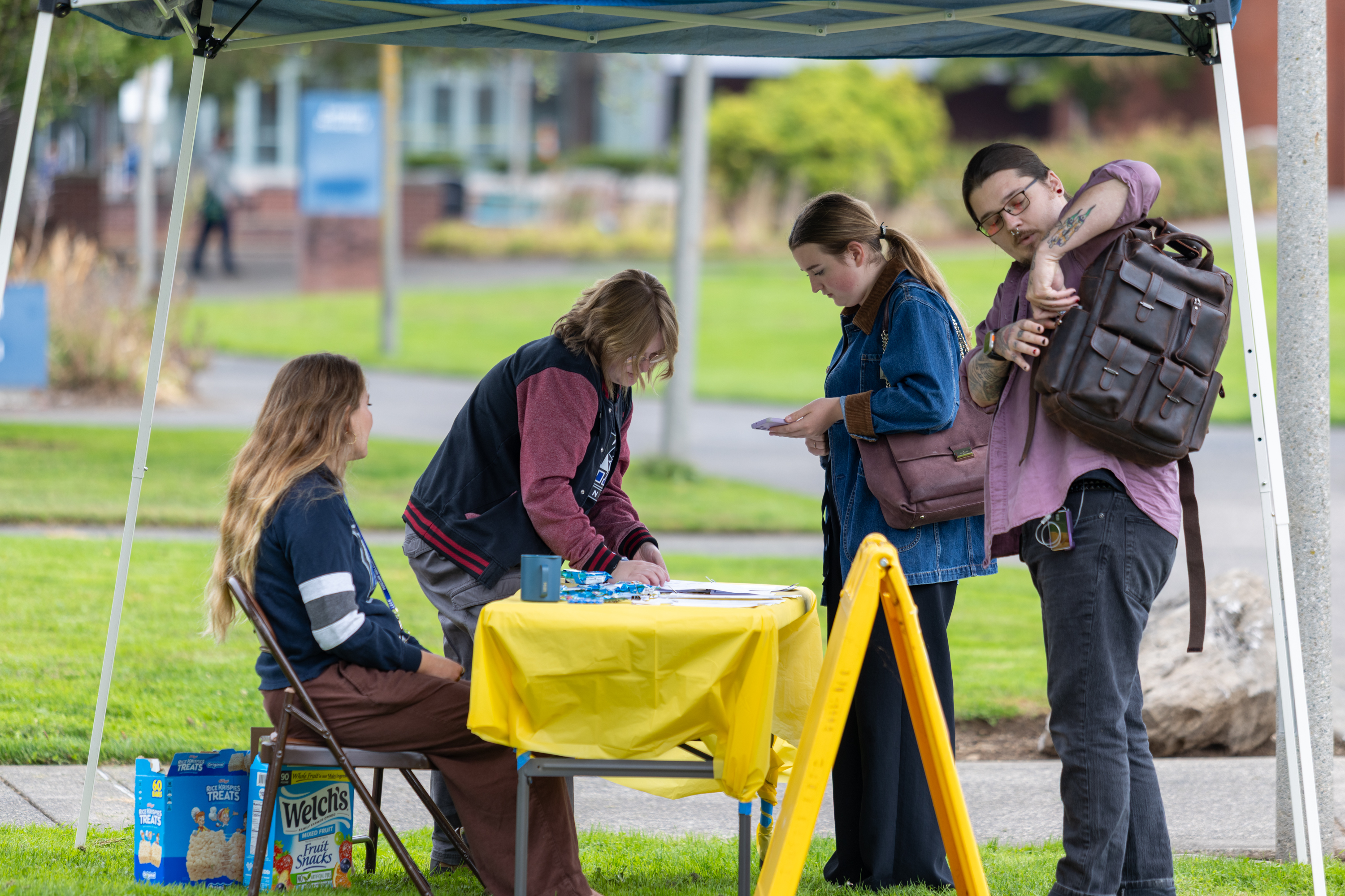 Clark employees assist students at an information table outside