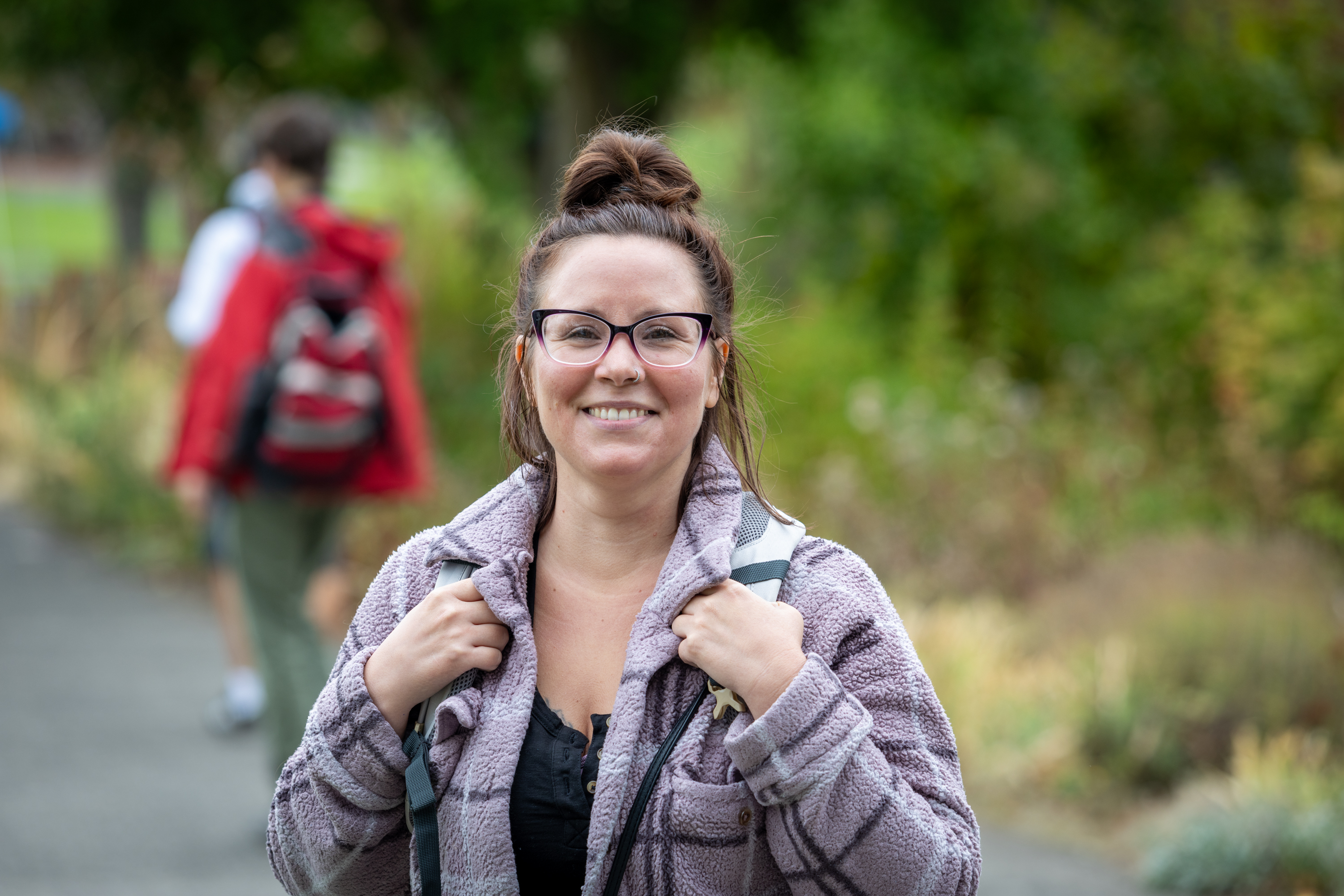 Student with backpack smiles at the camera