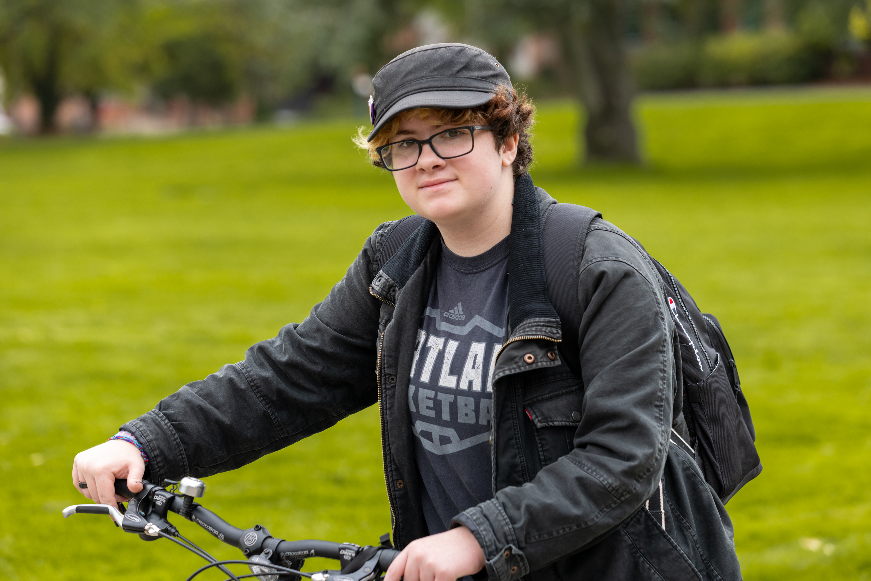 Student holds bicycle handles as they look at the camera