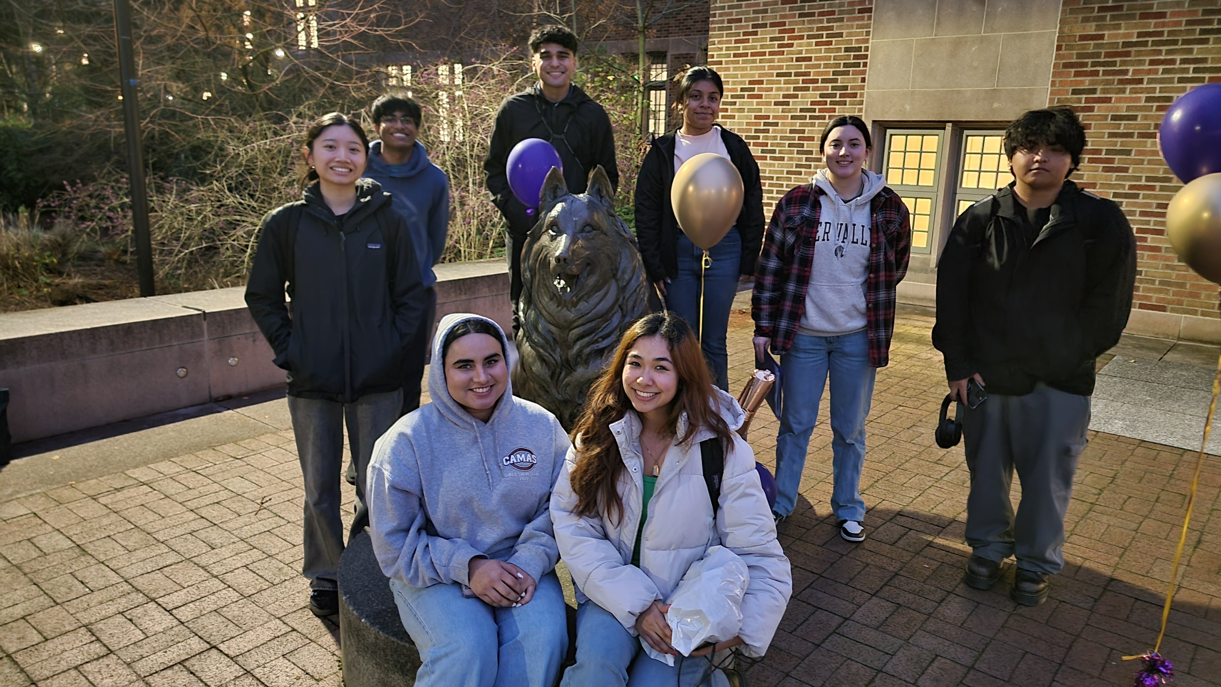 Students standing in front of University of Washington statue